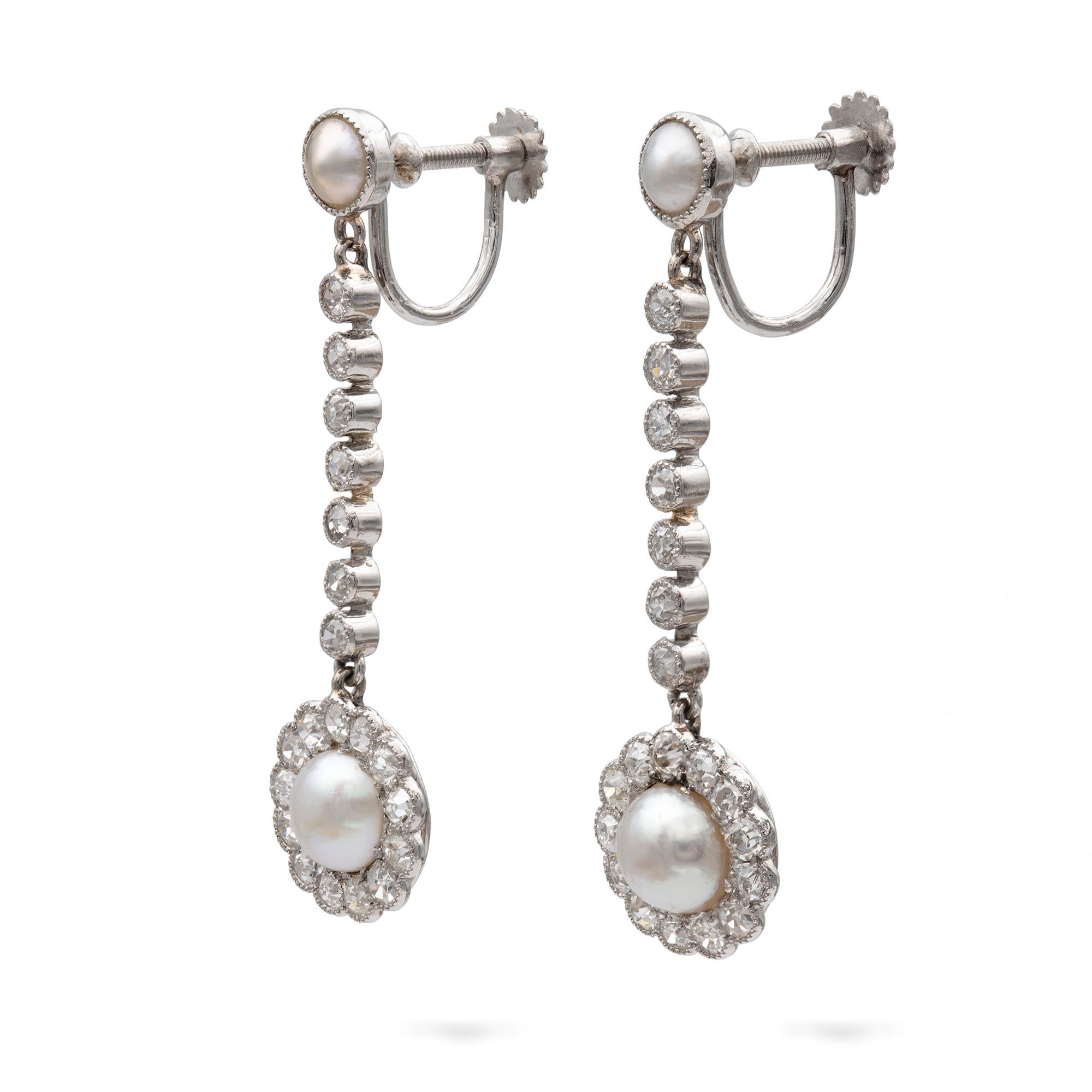 A pair of Edwardian natural pearl and diamond drop earrings, each consisting of a natural pearl surrounded by thirteen old brilliant-cut diamonds, suspended from a line of seven rose-cut diamonds in a rub-over setting, suspended by a single natural