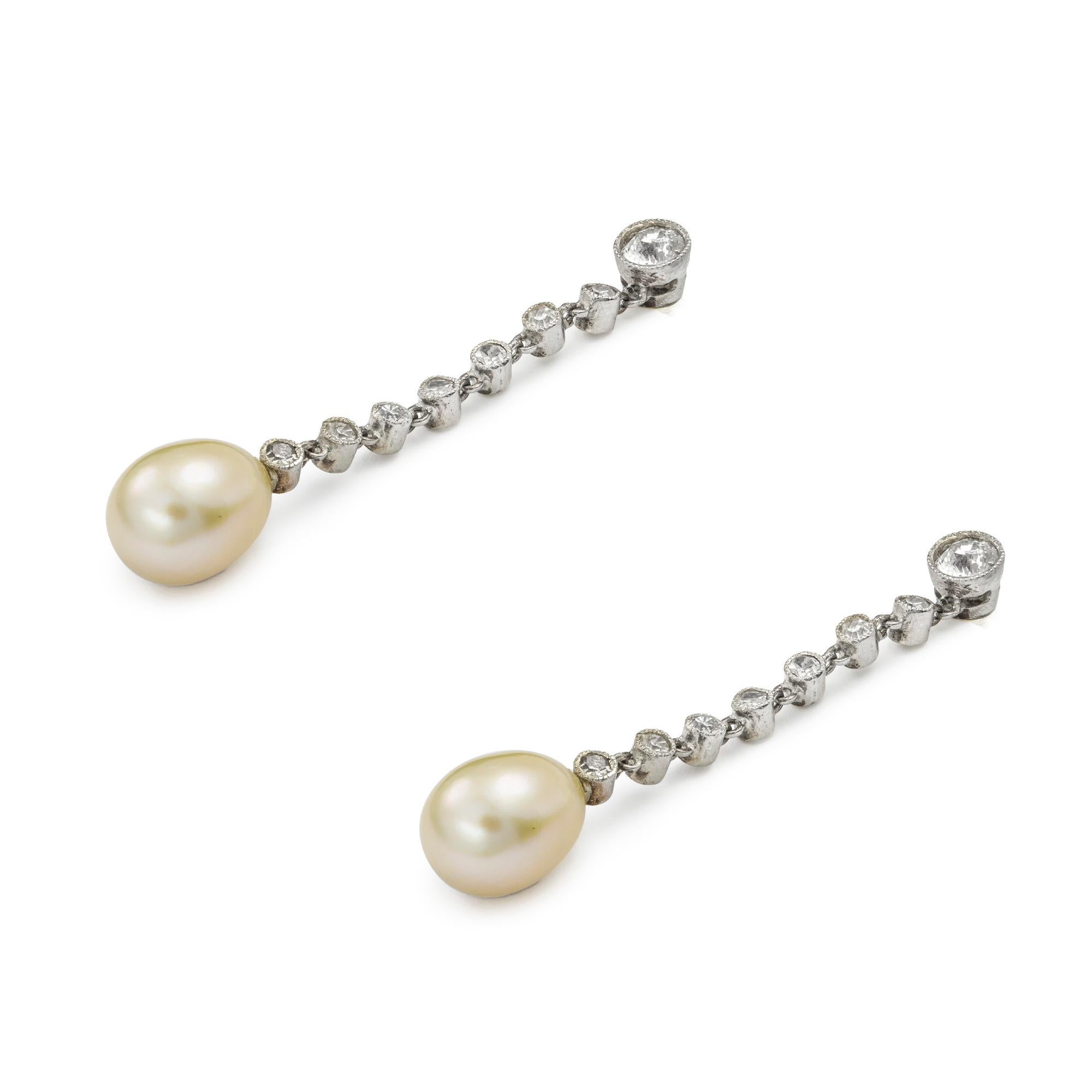 A pair of Edwardian pearl and diamond drop earrings, each earring with a tear-drop shaped pearl, accompanied by GCS report stating to be natural saltwater, suspended by a run of nine old European and Swiss-cut diamonds, the diamonds estimated to