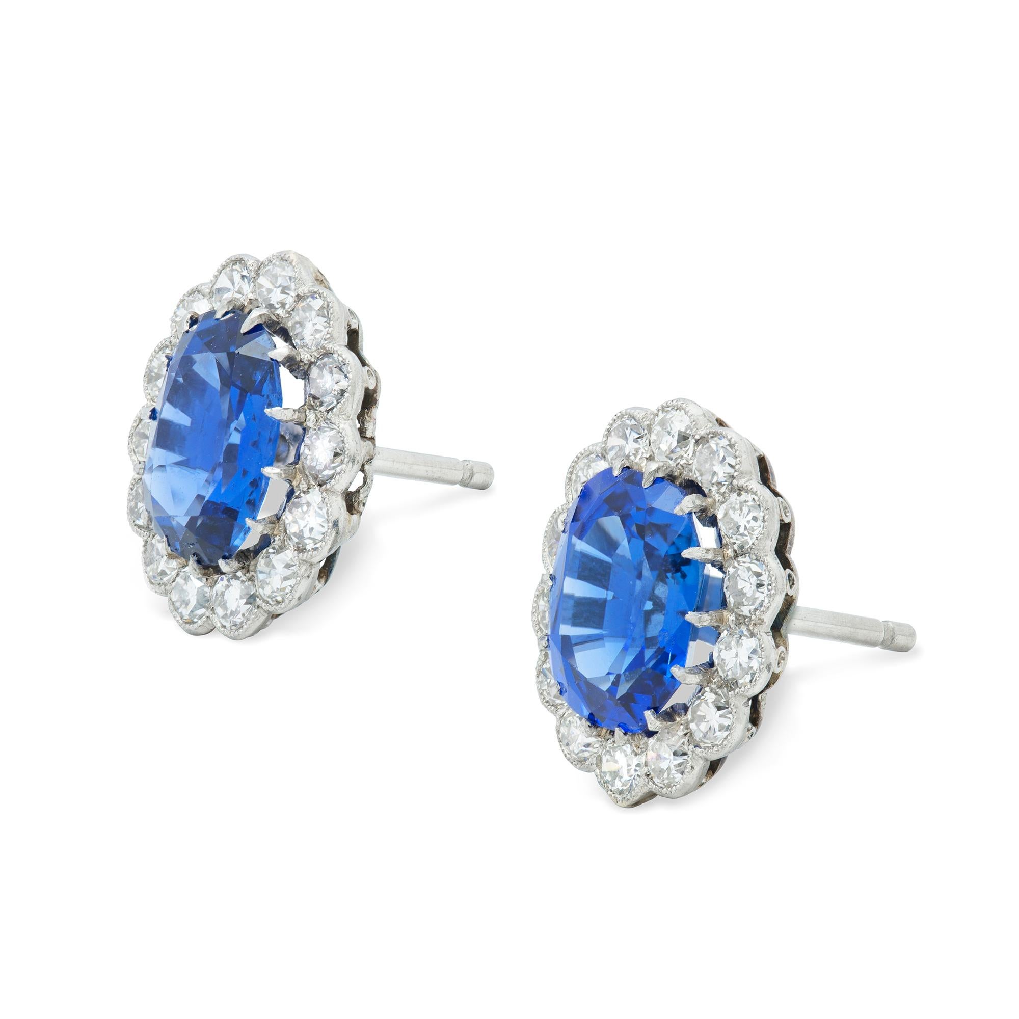 A pair of George V sapphire and diamond cluster earrings, each earring set with an oval-shaped faceted sapphire, total sapphire weight 3.66 carats, accompanied by GCS Report stating to be of Burmese origin with no indication of heat treatment,