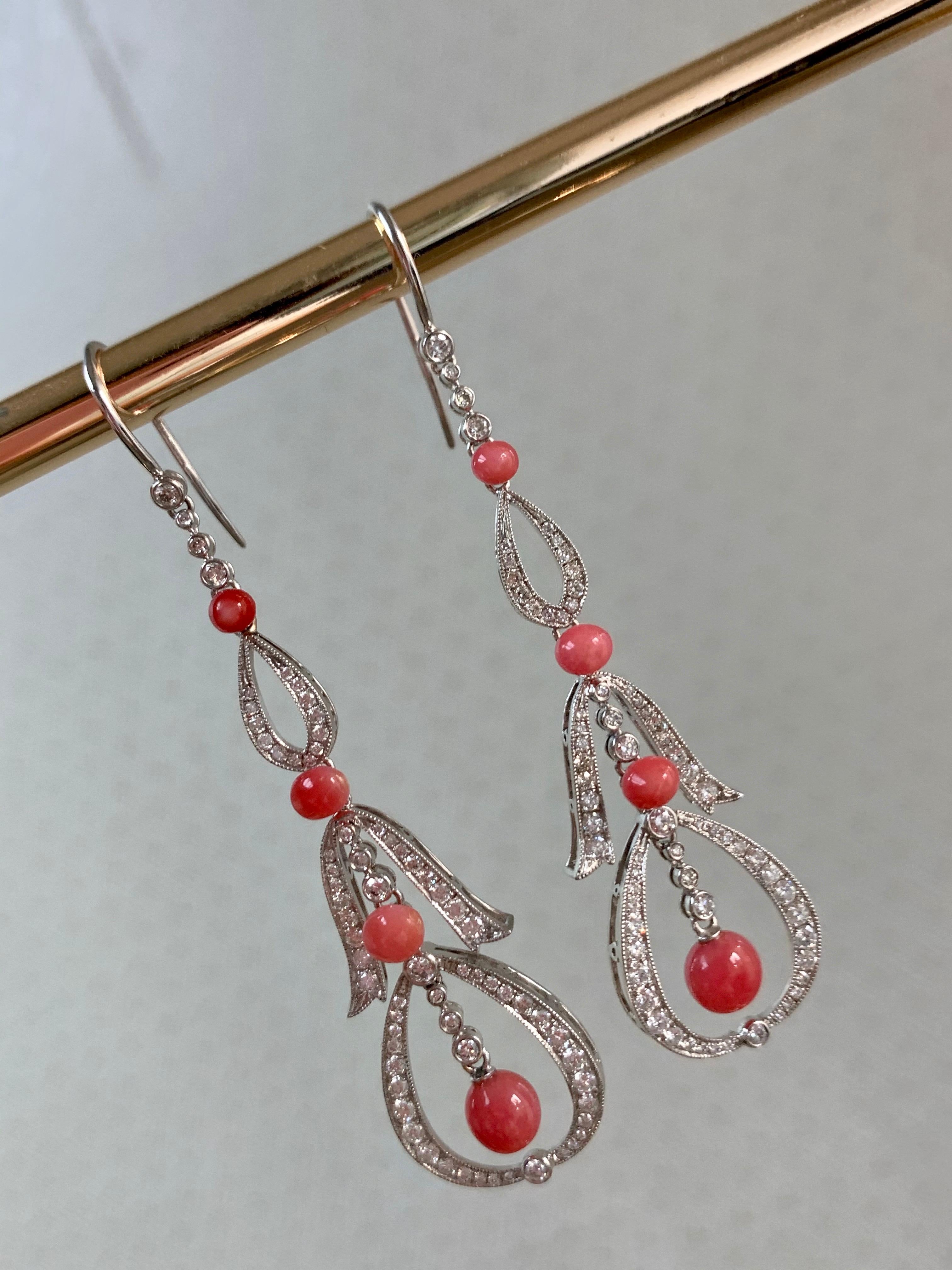 A pair of conch pearl and diamond drop earrings, the articulated links millegrain-set with circular-cut diamonds and graduated conch pearls in white gold, shepherd's hook fittings, 6.8cm high. Perfect condition. 

