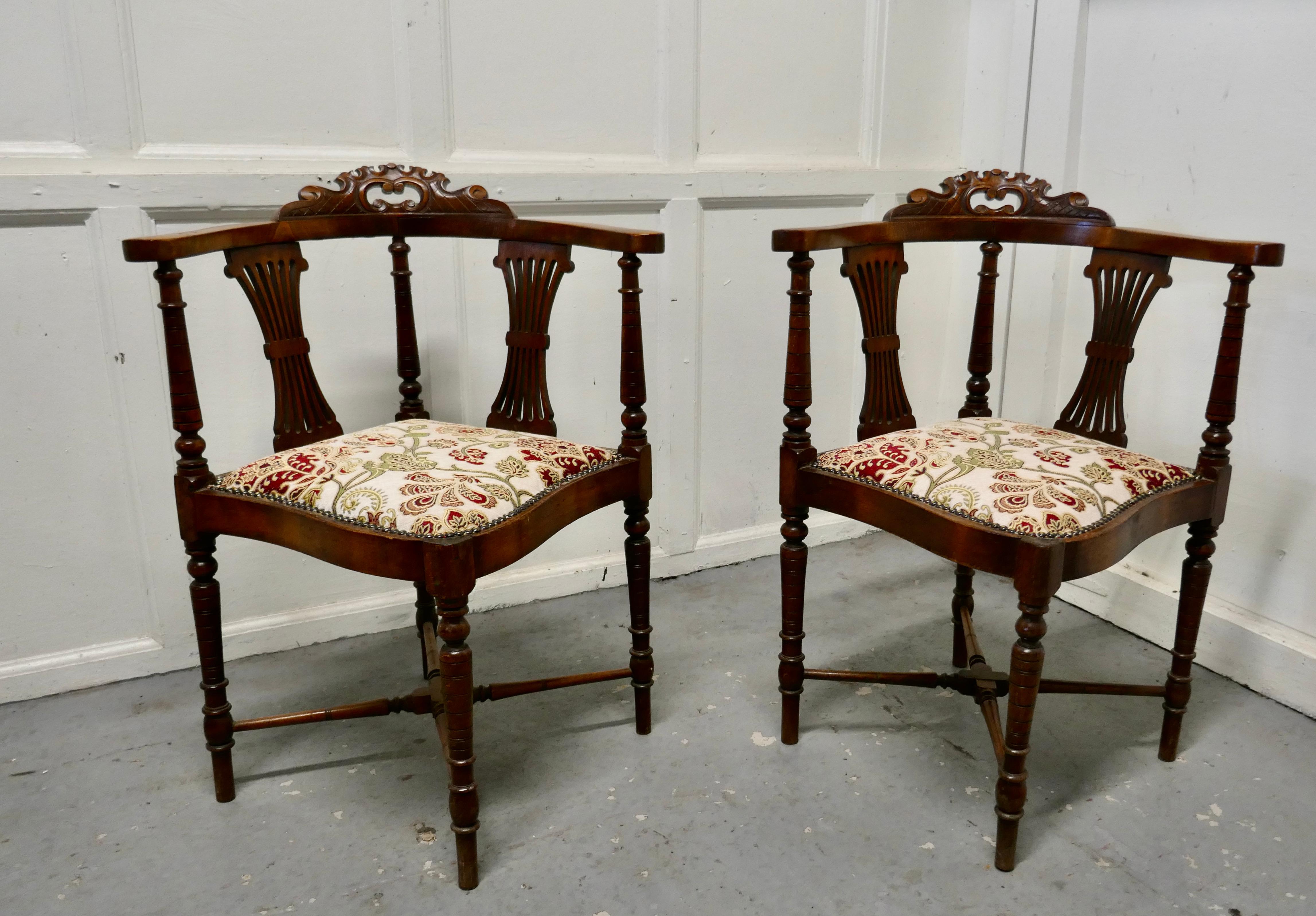 A pair of Edwardian walnut corner arm chairs

A beautiful pair of seats, on the back the chairs have gathered fan splats, framed by turned spindles, set on turned stretchered legs 

The seats have new upholstery in linen with silk embroidery
