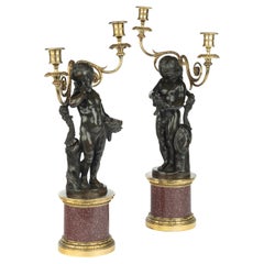 A pair of Egyptian porphyry and bronze candelabra after Charles-Antoine Bridan