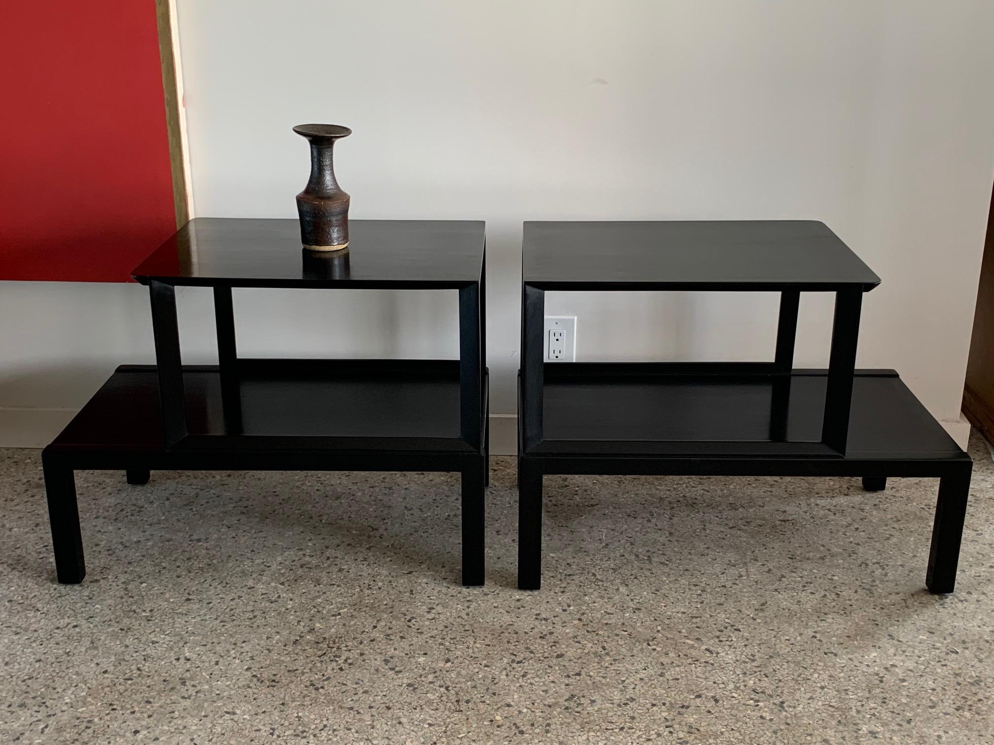 A pair of elegant Edward Wormley designed for Dunbar two-tier tables. Black lacquer, hand polished finish, well made with architectural details.