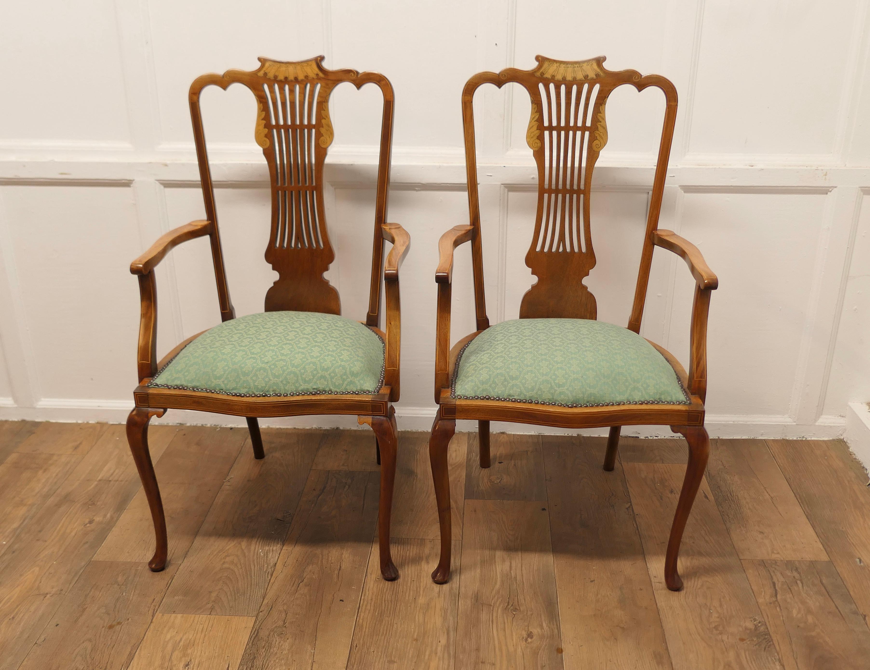 A Pair of Elegant Edwardian Upholstered  Arm Chairs 

This is a very handsome pair of Edwardian chairs, the chairs have aesthetic movement pierced and decorated backs
The chairs are made in a light coloured walnut and have a scroll decoration