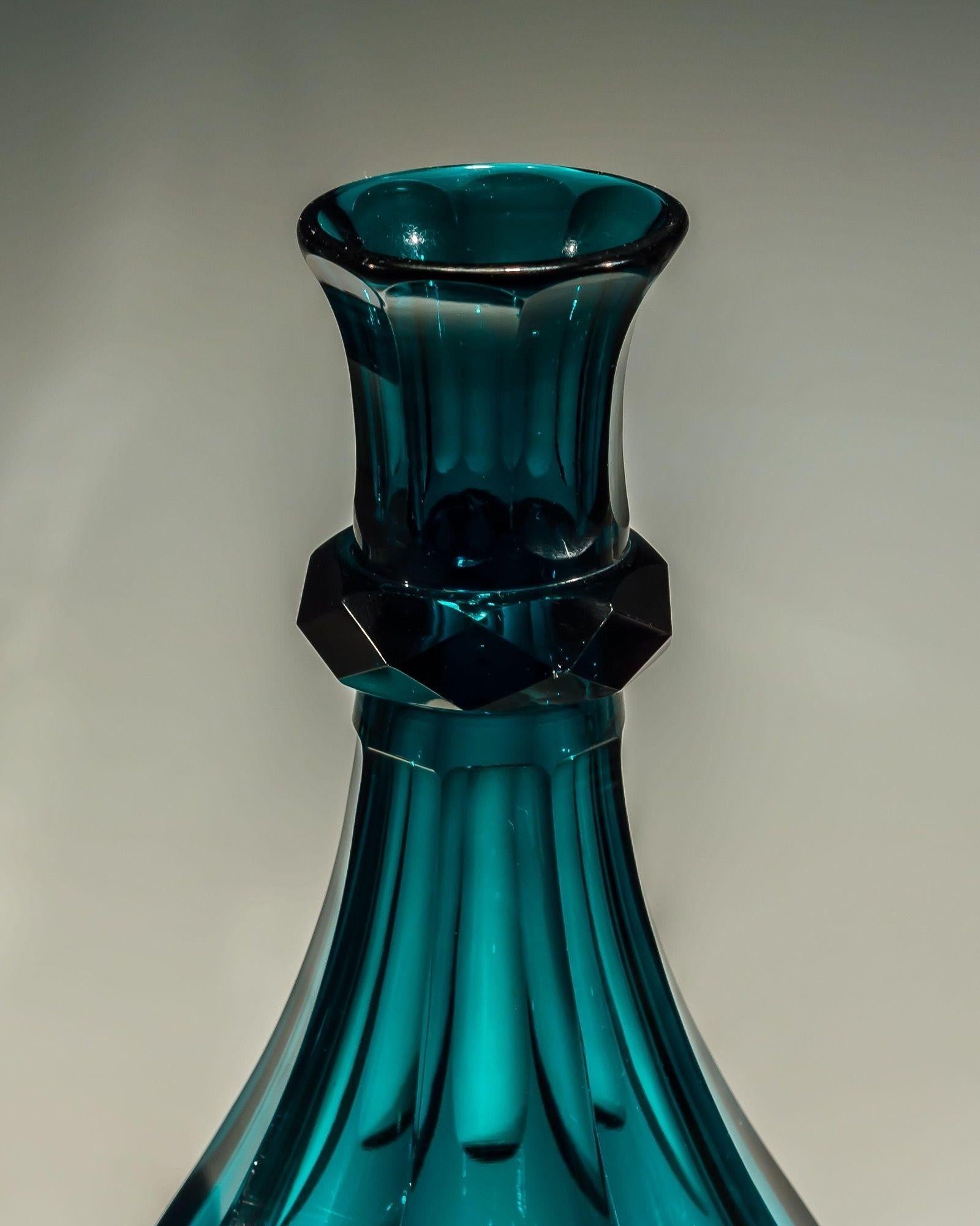 A pair of slice cut, elegant green glass serving carafes.