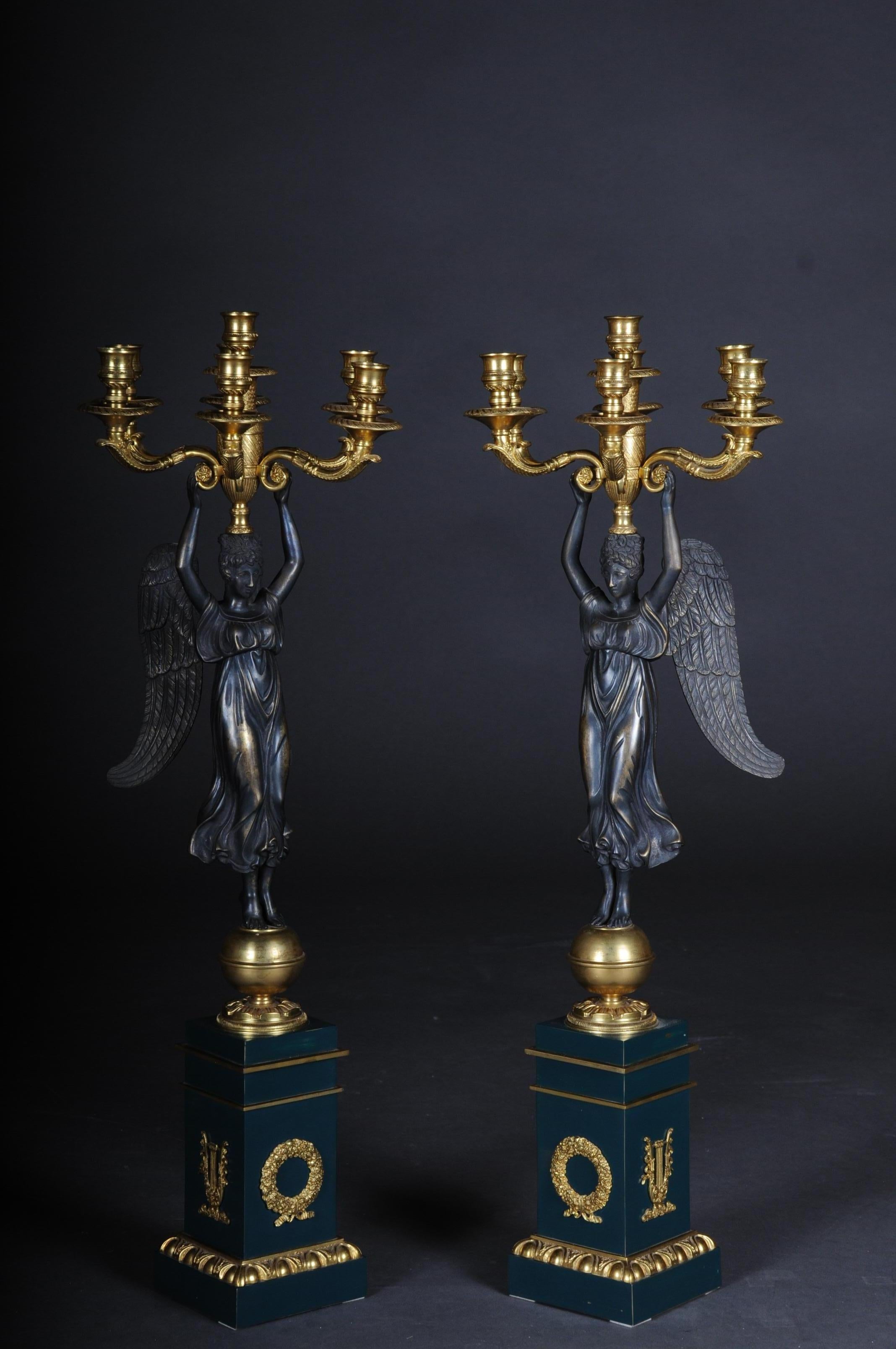 A pair of Empire ceremonial candelabras / candlesticks after P. P. Thomire


Victoria standing on a gold ball in a long, pleated robe, carrying a vase with a central shaft and 7 curved light arms with round drip plates and cylindrical spouts, on
