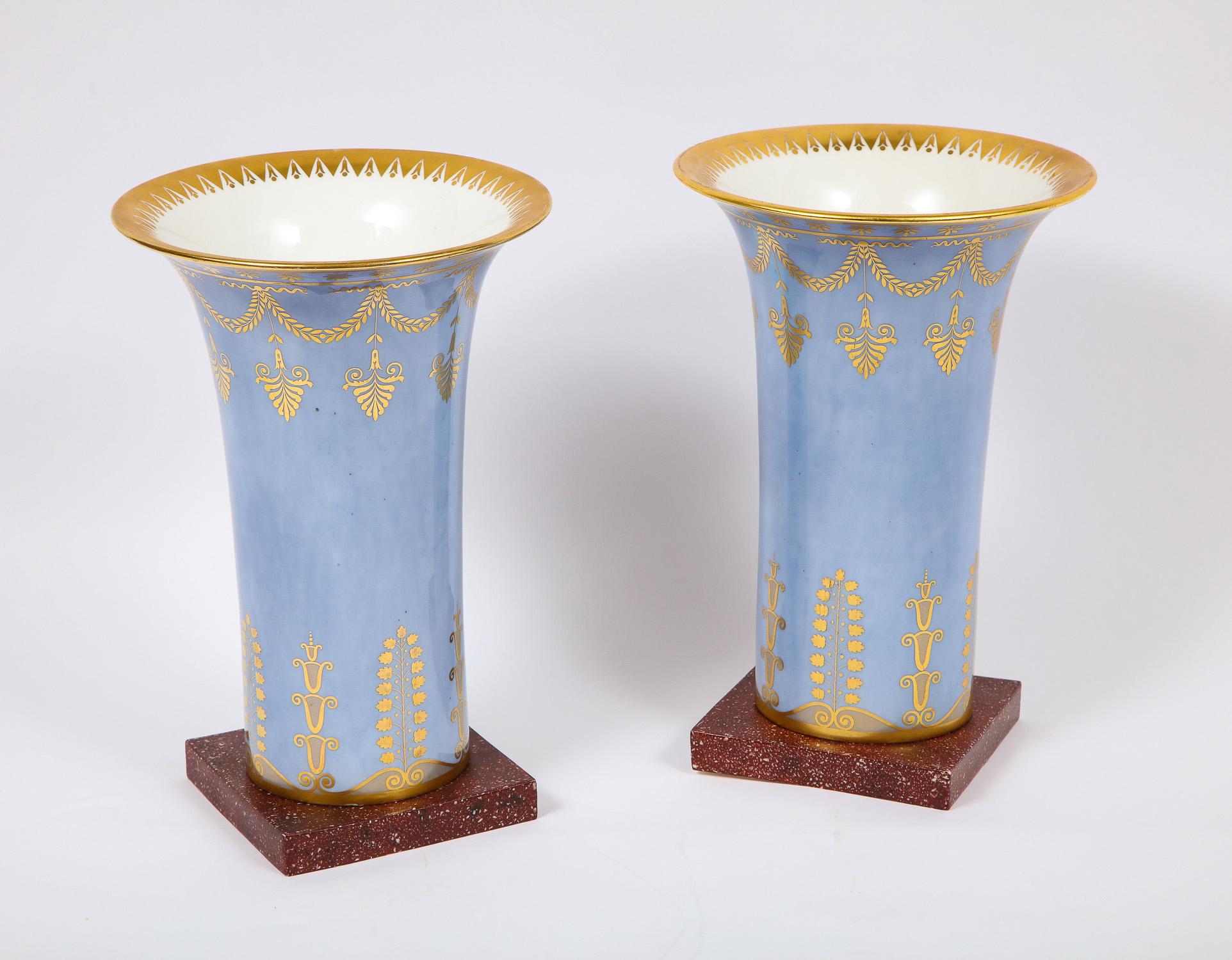 A very unusual and quite large pair of Empire period Sèvres Porcelain pale Celeste blue and faux porphyry ground vases. Each vase is intricately hand painted with meticulous detail and further adorned with 24-karat hand painted gilt decoration. The