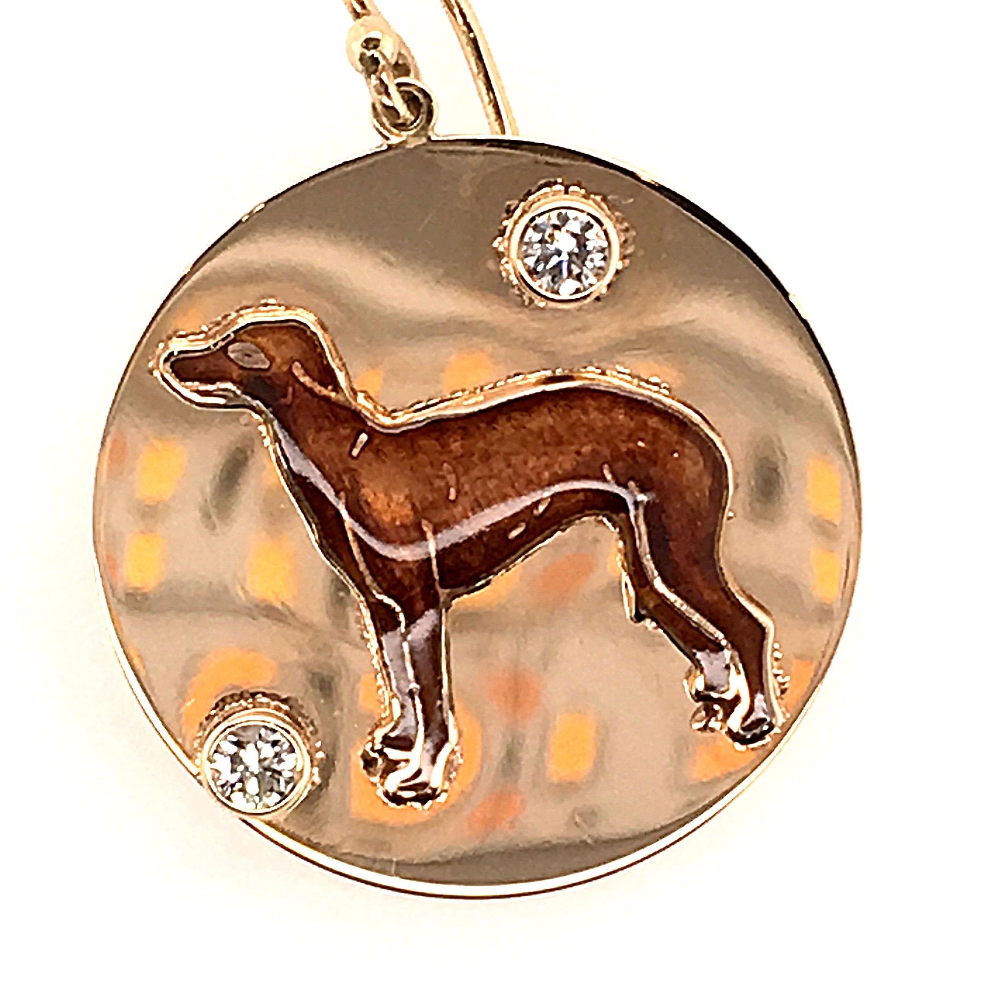 A pair of 14 karat yellow gold, enamel and diamond earrings.  Each earring suspends a 14 karat yellow gold disk centering a brown enameled dog in profile from a 14 karat yellow gold earwire through a small bale.  Each earring is accented by two