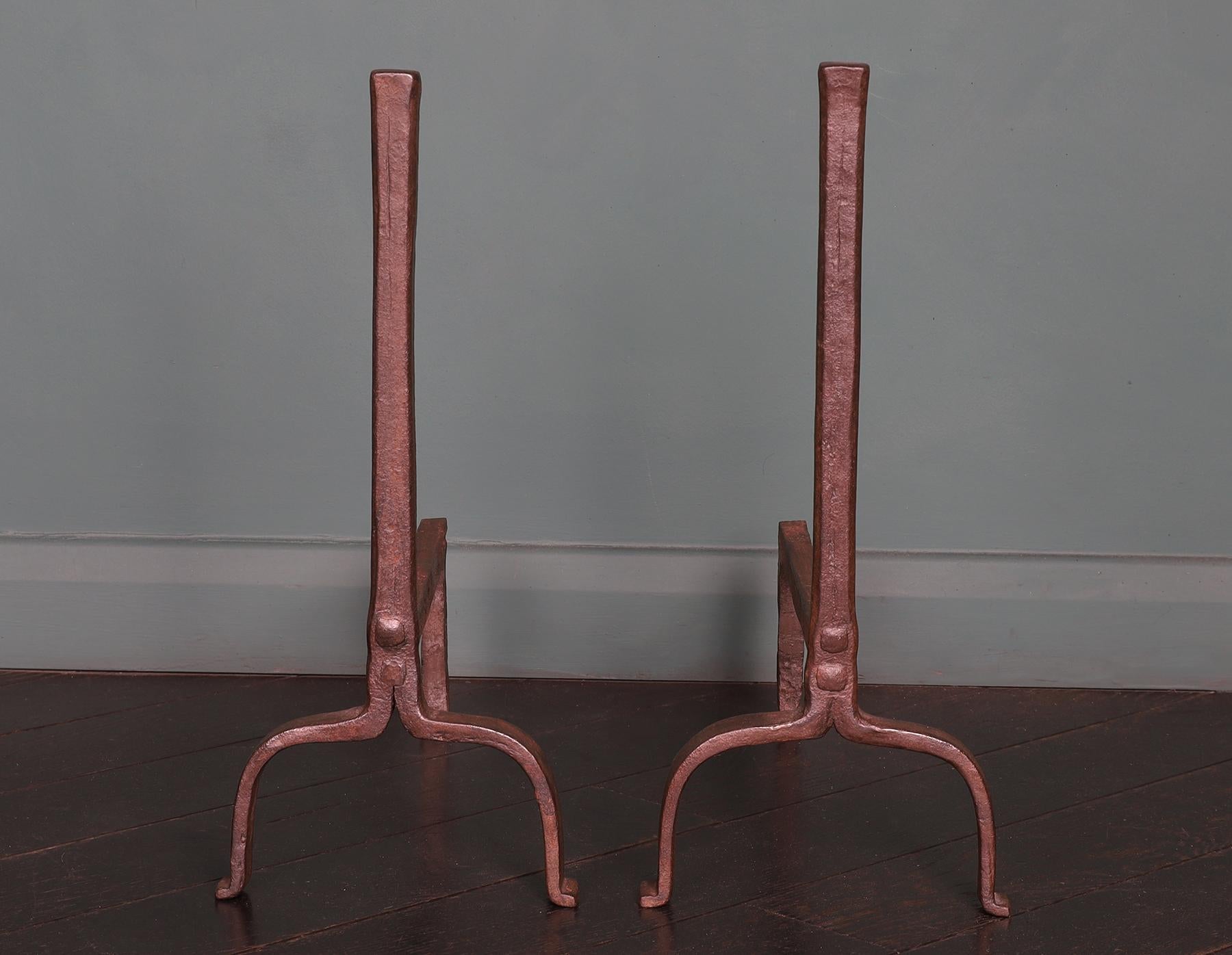 A pair of English 18th century wrought fireplace fire dogs. The standard with ‘jumped-up’ top on arched supports and rear spit-hook.
The riveted rear log-supports can be adjusted if required. Wax finish.
Circa 1790