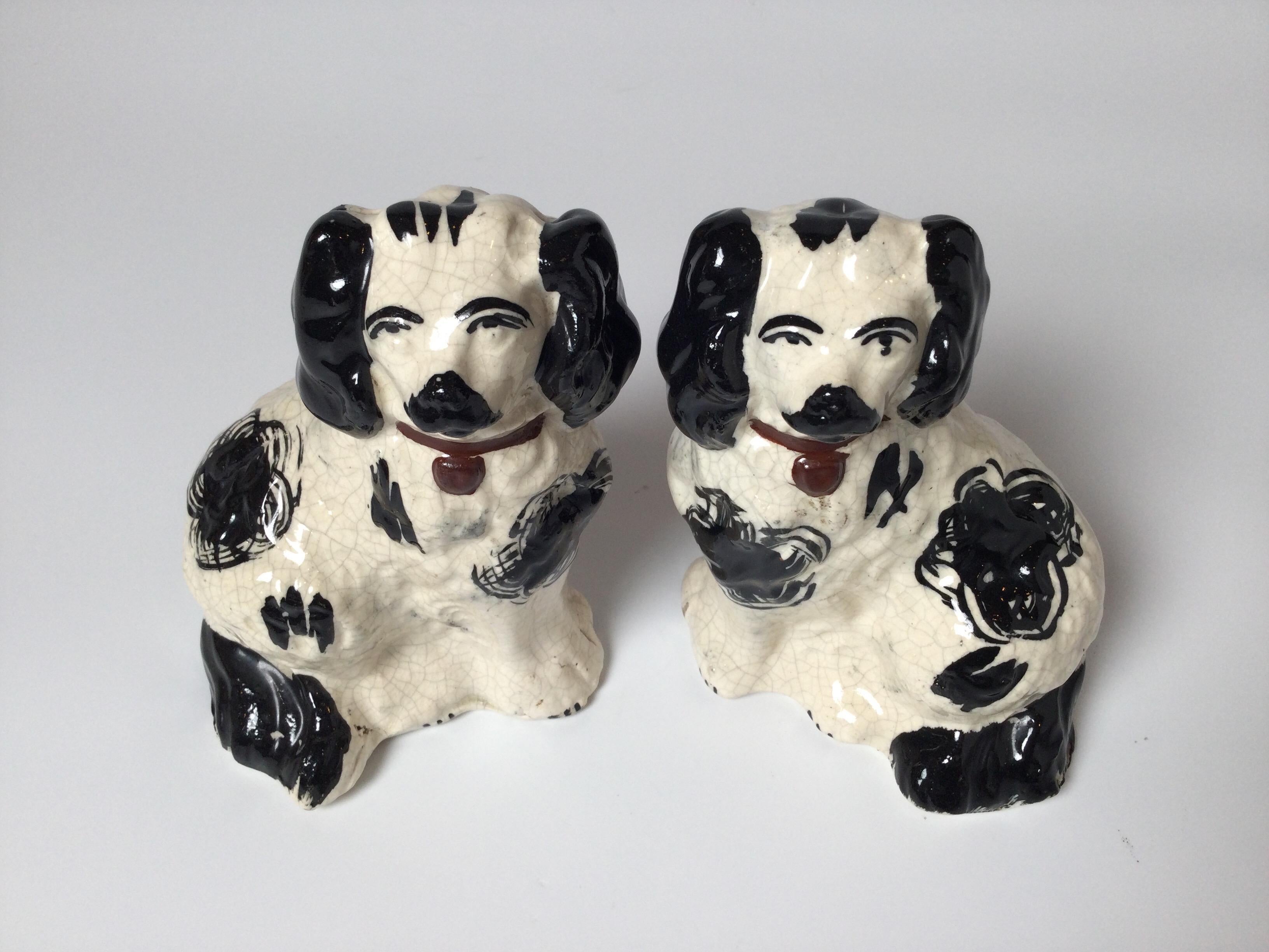 A pair of antique English Staffordshire blak and white spaniels. Measure: 6” tall.