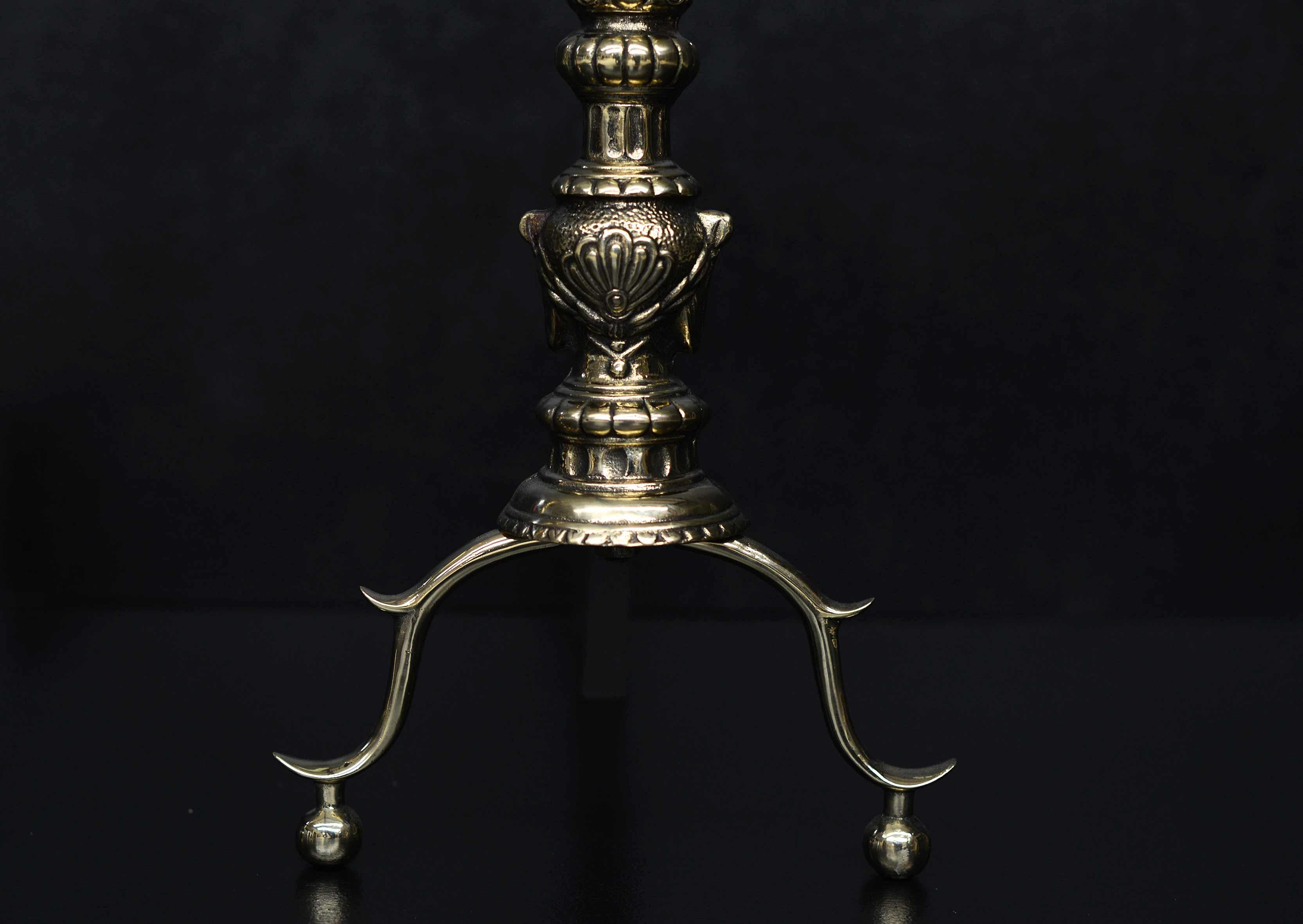 A pair of English brass firedogs. The shaped feet with leaf motif to shaft surmounted by gadrooned ball finial, 19th century.

Measures: Height: 570 mm 22 ½