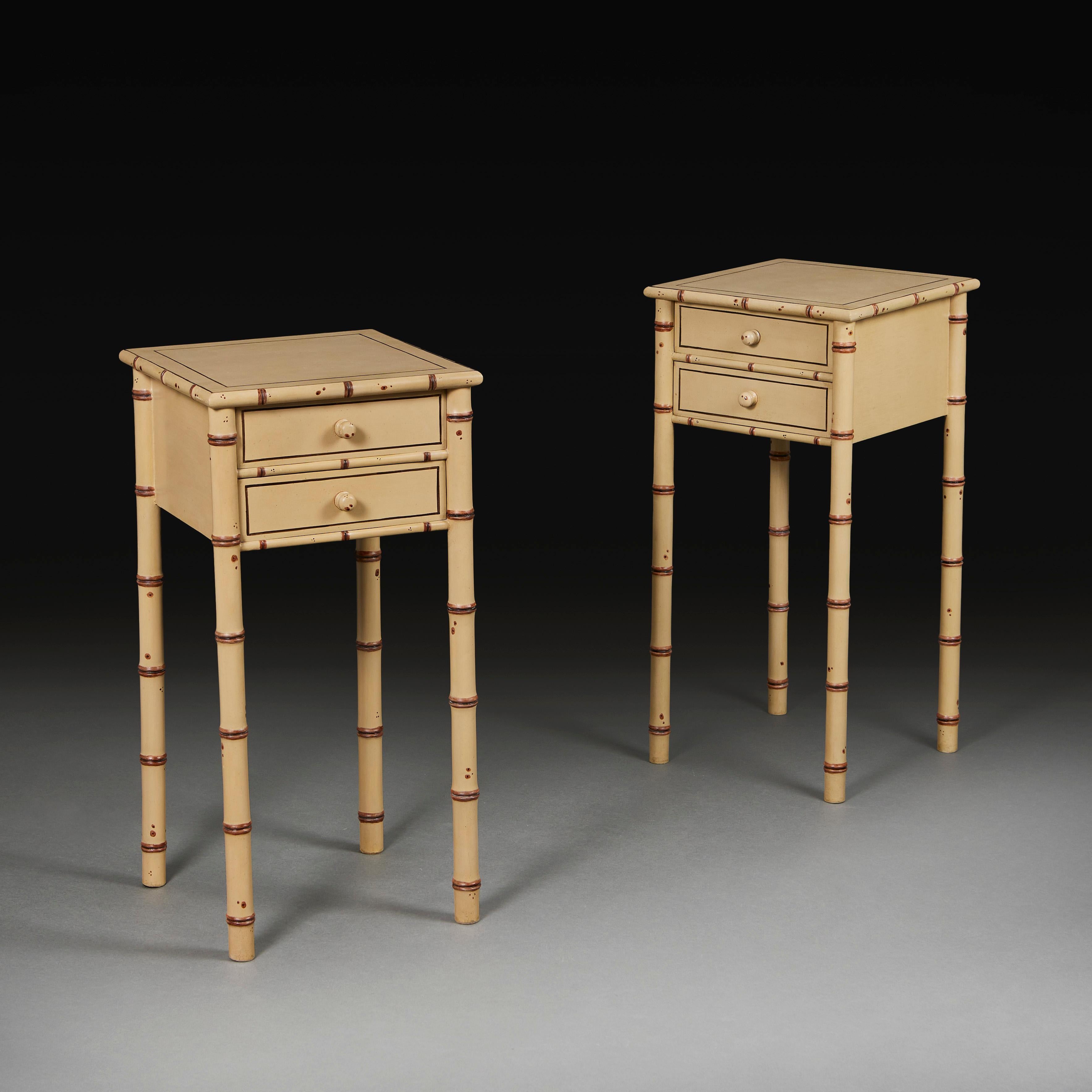 A pair of Edwardian faux bamboo painted bedside tables, painted in cream and brown to simulate bamboo wood, of square form, each opening with two drawers to the front, supported on four bamboo legs.