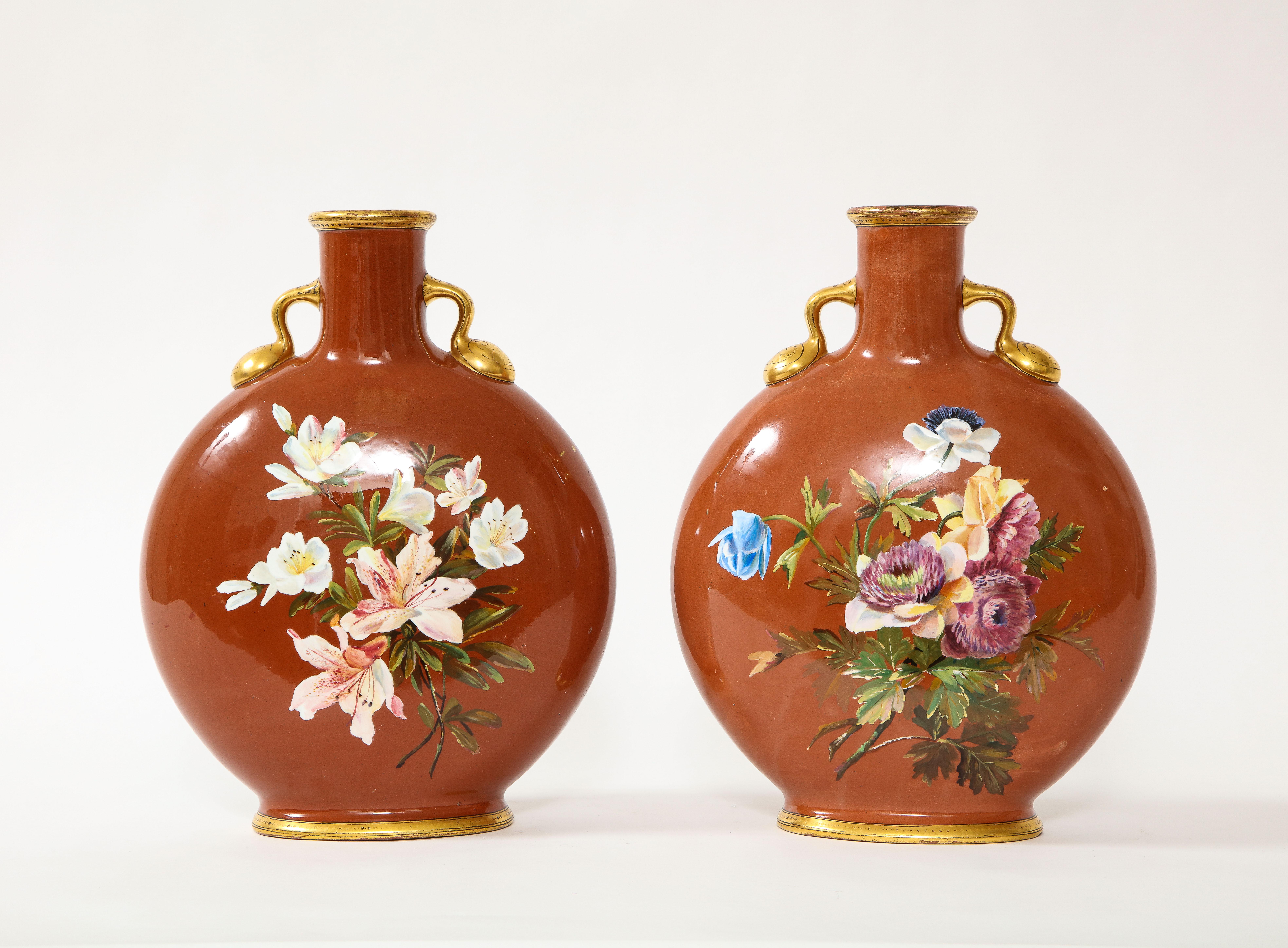 A fabulous pair of Louis XVI style 19th century English Mintons Coral ground floral painted moon flasks with 24k hand-painted decoration. Exceptional in quality and craftsmanship, these moon flasks are fabulously hand-painted with many different