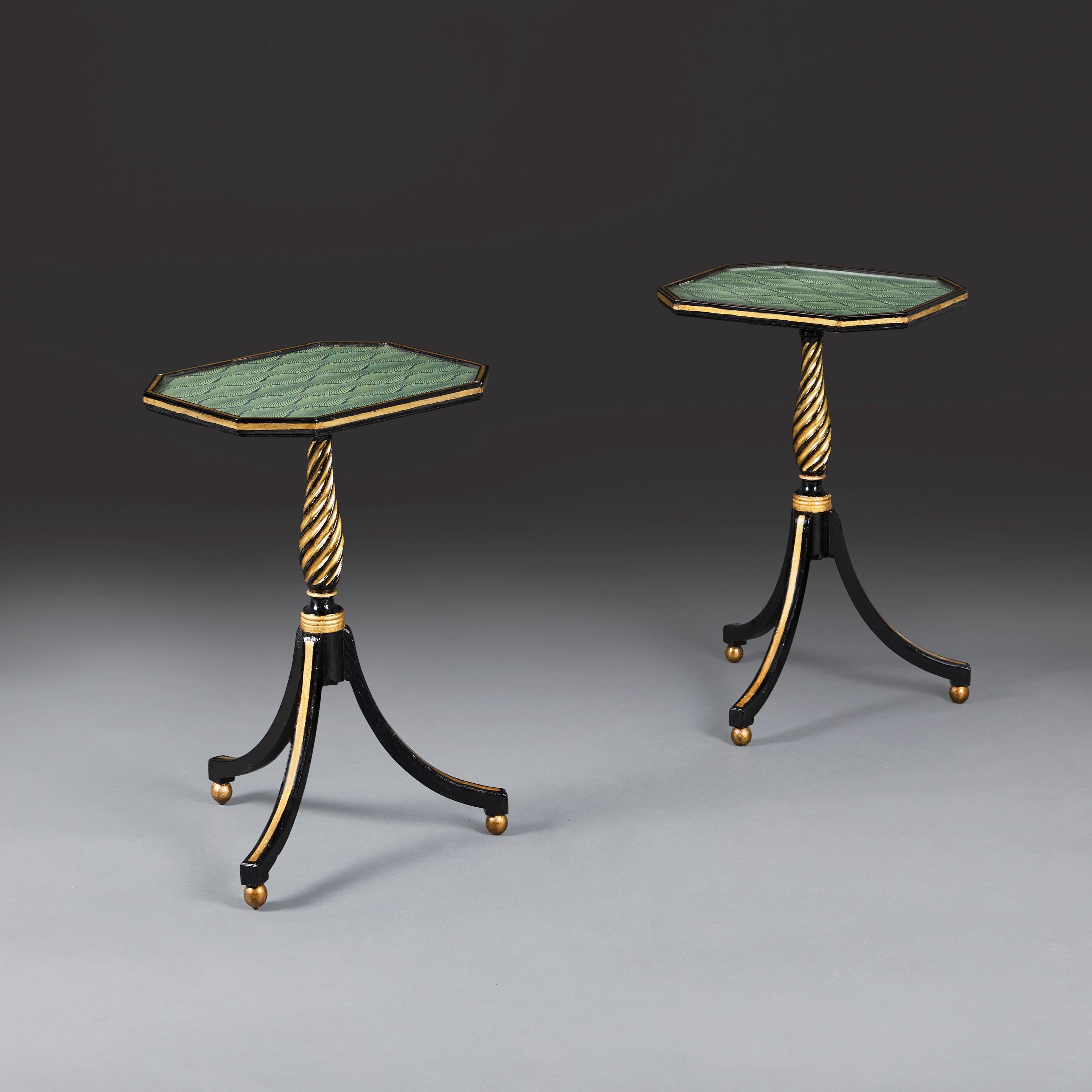 England, circa 1820.

A pair of octagonal Regency period ebonised and gilded occasional tables, the tops lined with feathered Edwardian paper, supported by a twisted stem and tripod legs terminating in gilt ball feet.

Height 60.00
