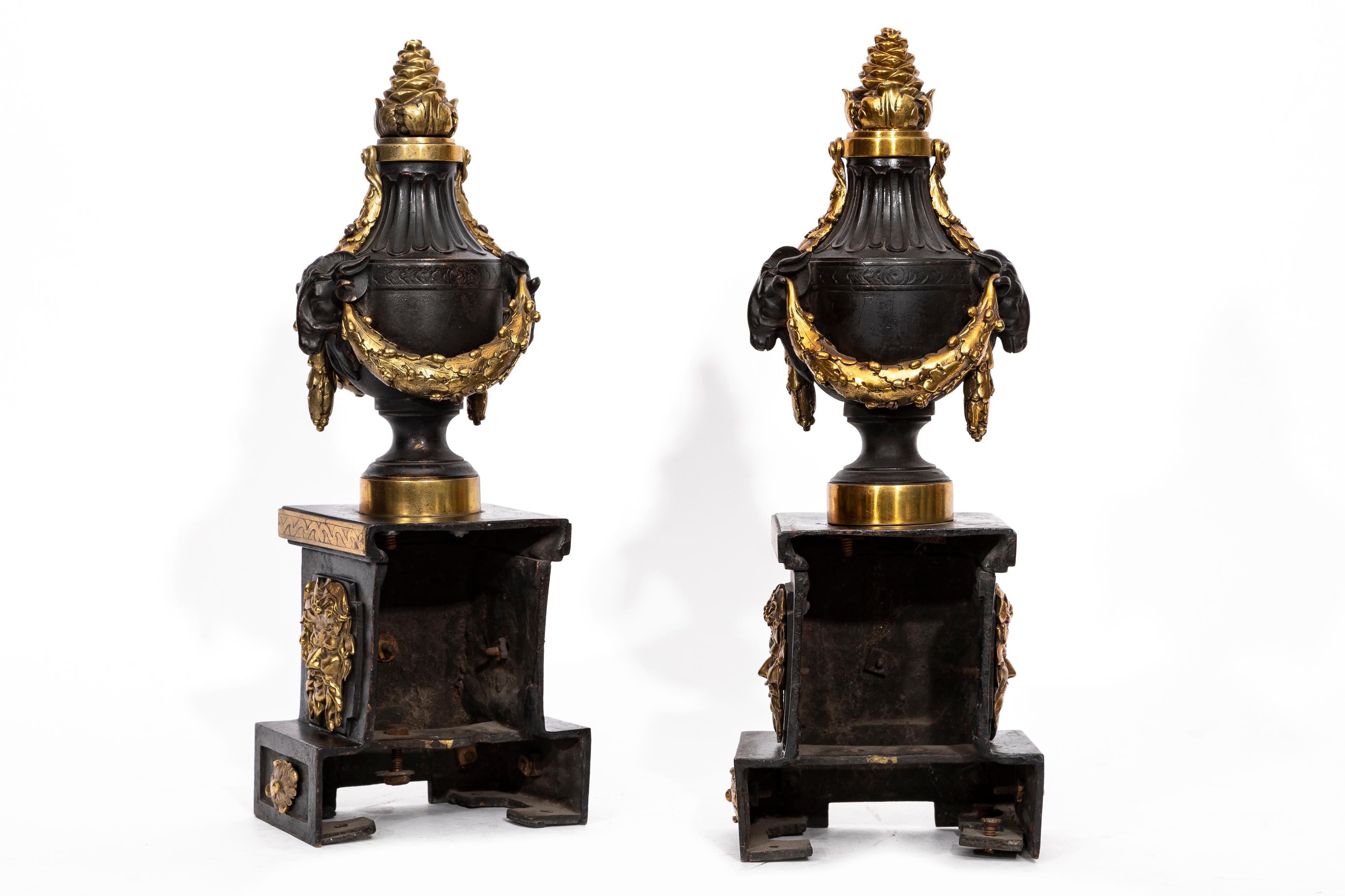Bronze A Pair of English Regency Patinated and Ormolu Rams Head Andirons For Sale