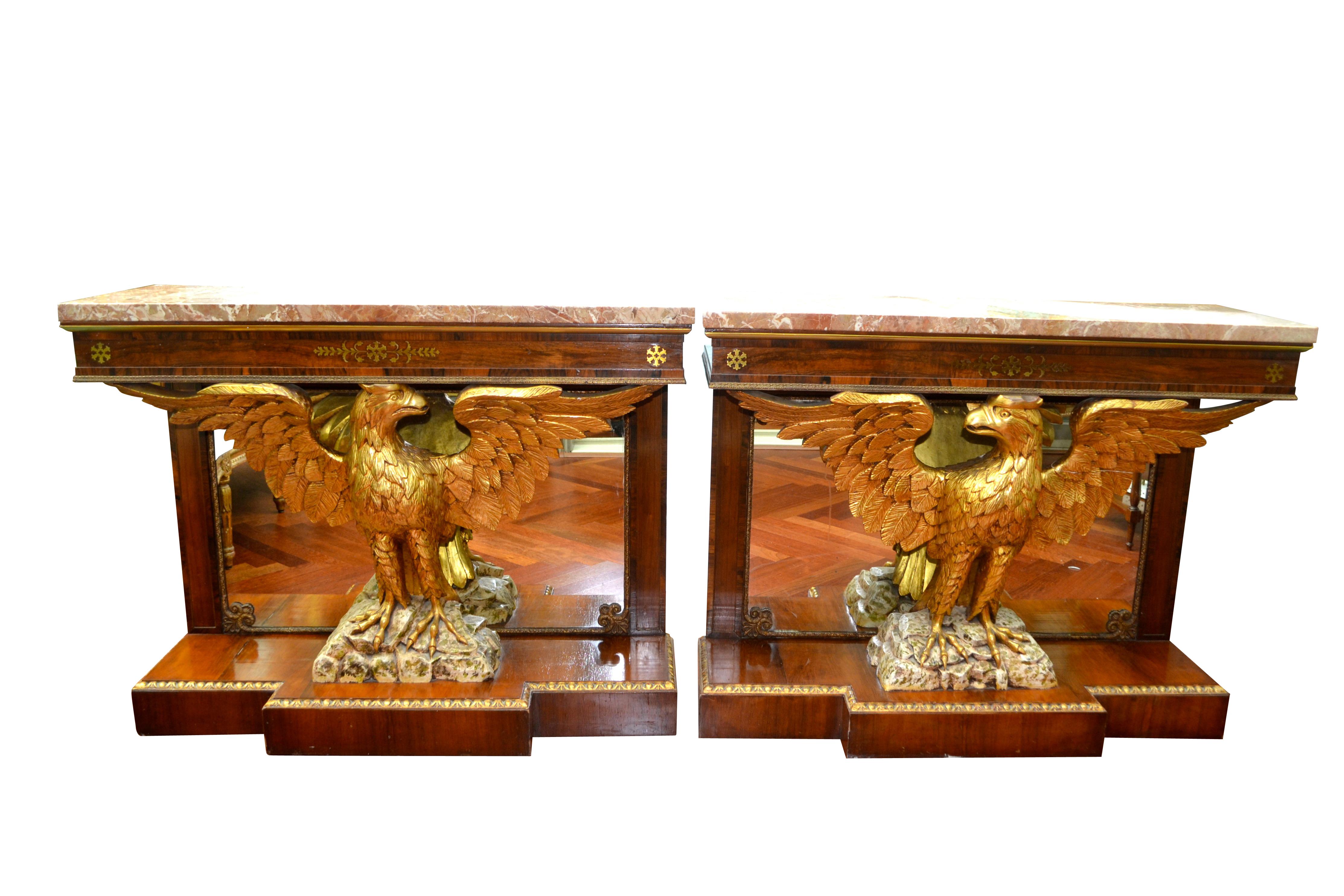 A pair of late 19th/early 20thC  English Regency style console tables in mahogany with brass inlay, gilded wood, and Breccia marble tops. The tops are each supported by carved and gilded wood eagle with their wings spread perched  on a  simulated