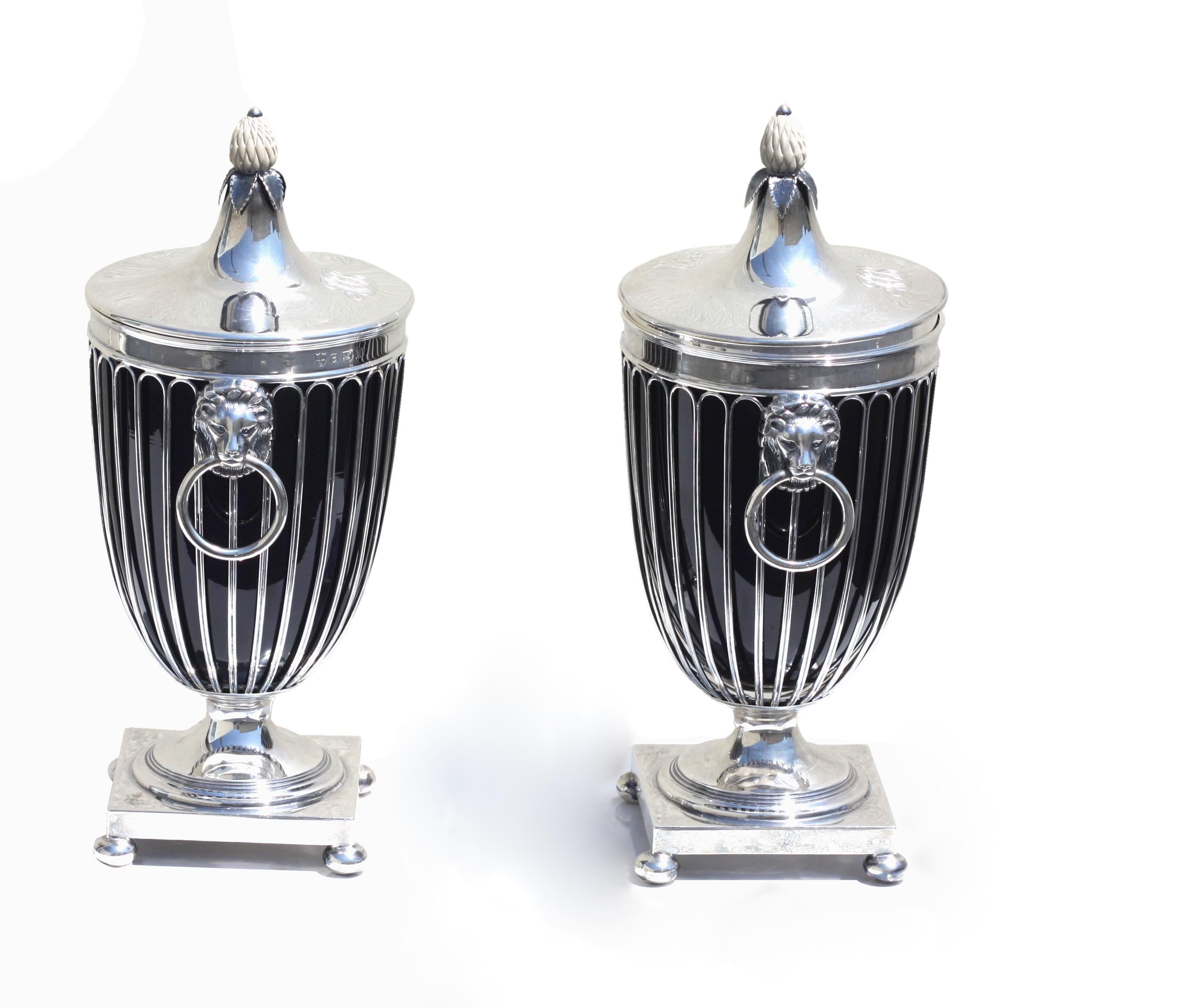 A pair of English silver vases and covers
Ellis Jacob Greenberg -Ellis & Co (Birmingham) Ltd-
in the neo-classical style; the body with fluted sides and plain rim, cast lion mask handles with ring pendants, embellished column on a spreading square