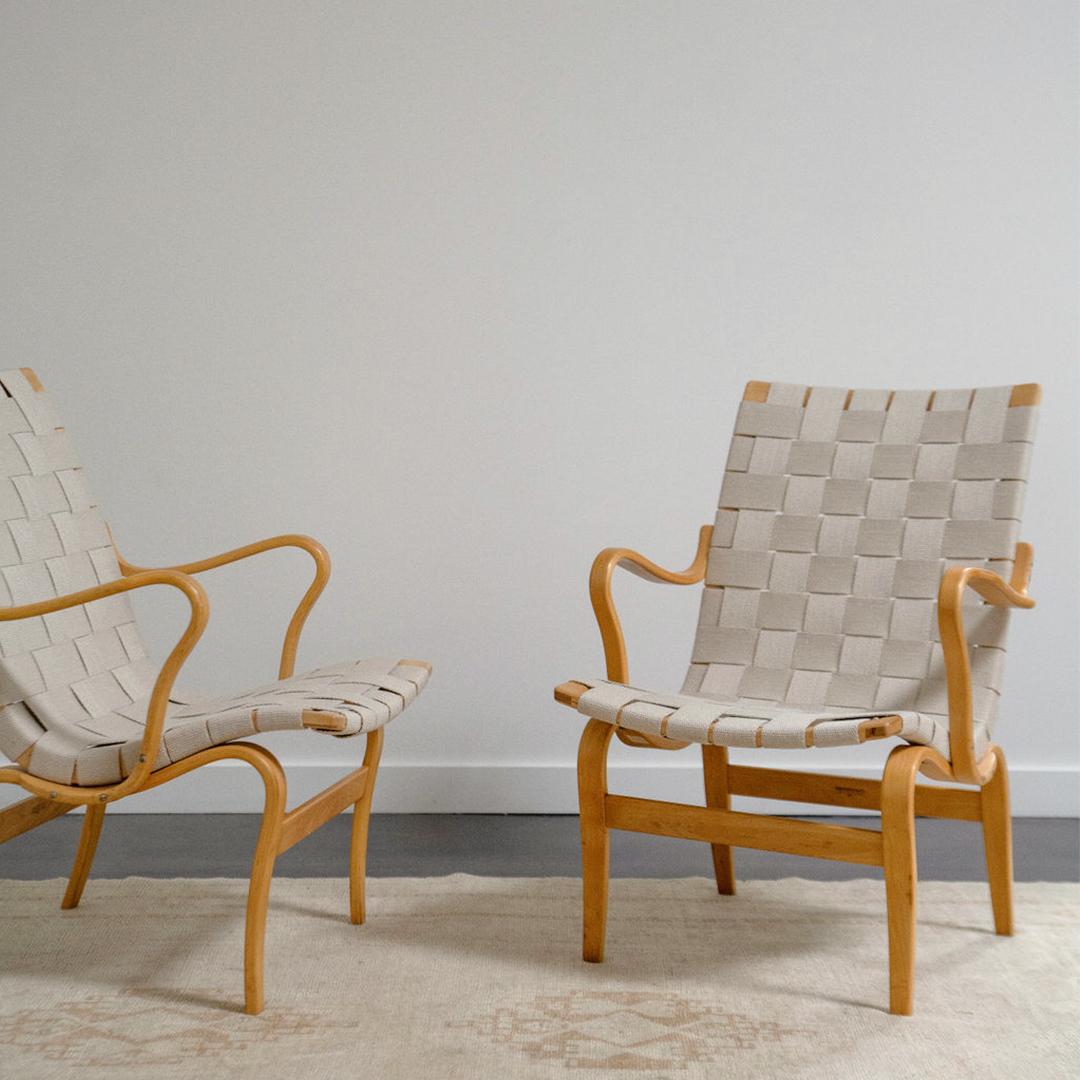 A pair of Mid-Century ‘Eva’ armchairs made of birch and braided hemp by Bruno Mathsson.  Crafted with precision and finesse, this iconic piece seamlessly blends functionality with Scandinavian sophistication. It’s minimalistic design and ergonomic