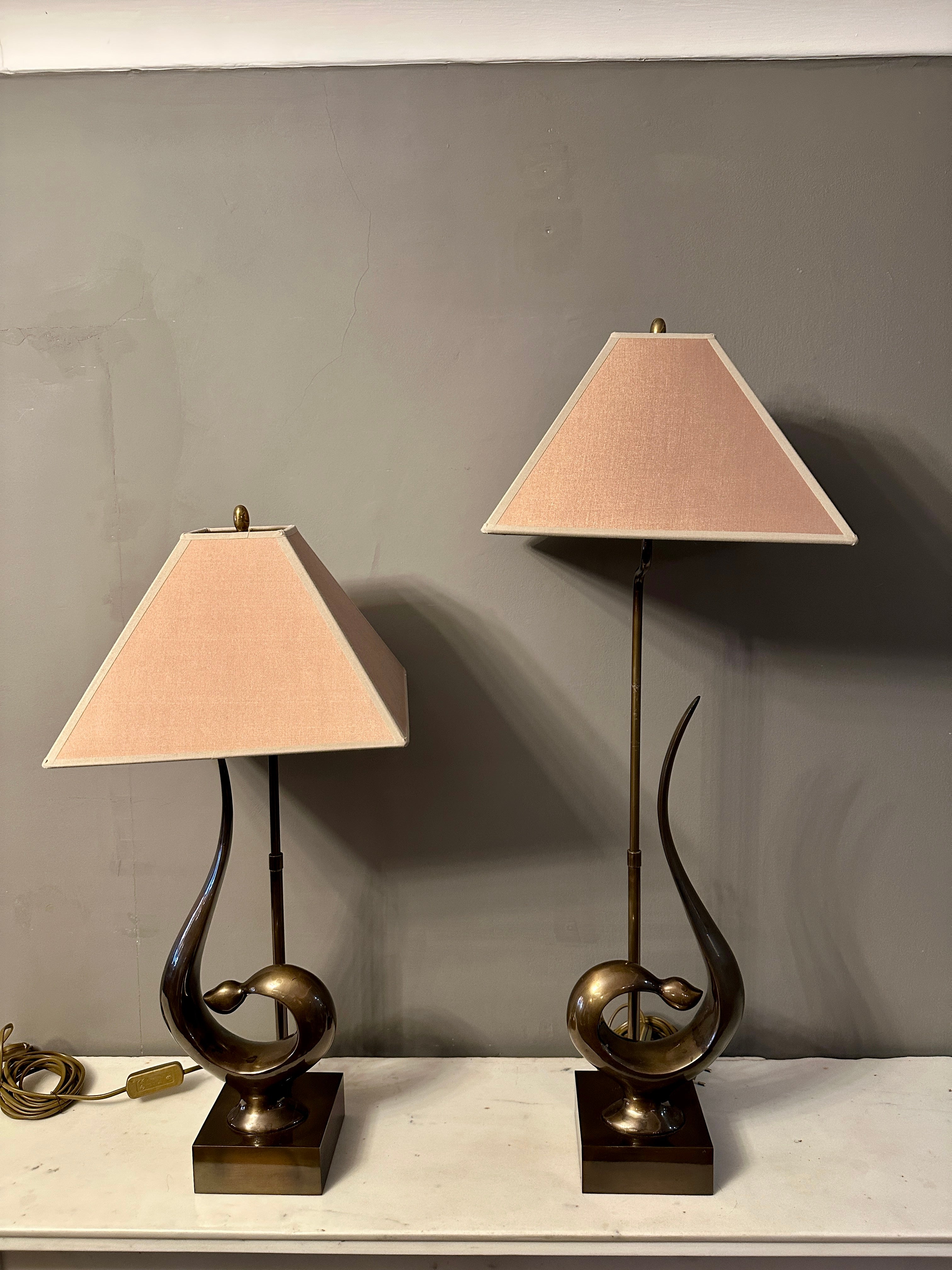 Paire de lampes de table stylisées et organiques en laiton patiné, avec des abat-jours en tissu doré. Le bras porteur de l'abat-jour peut s'allonger de 12 cm en hauteur. La base carrée en laiton supporte à la fois le design sculptural et le bras