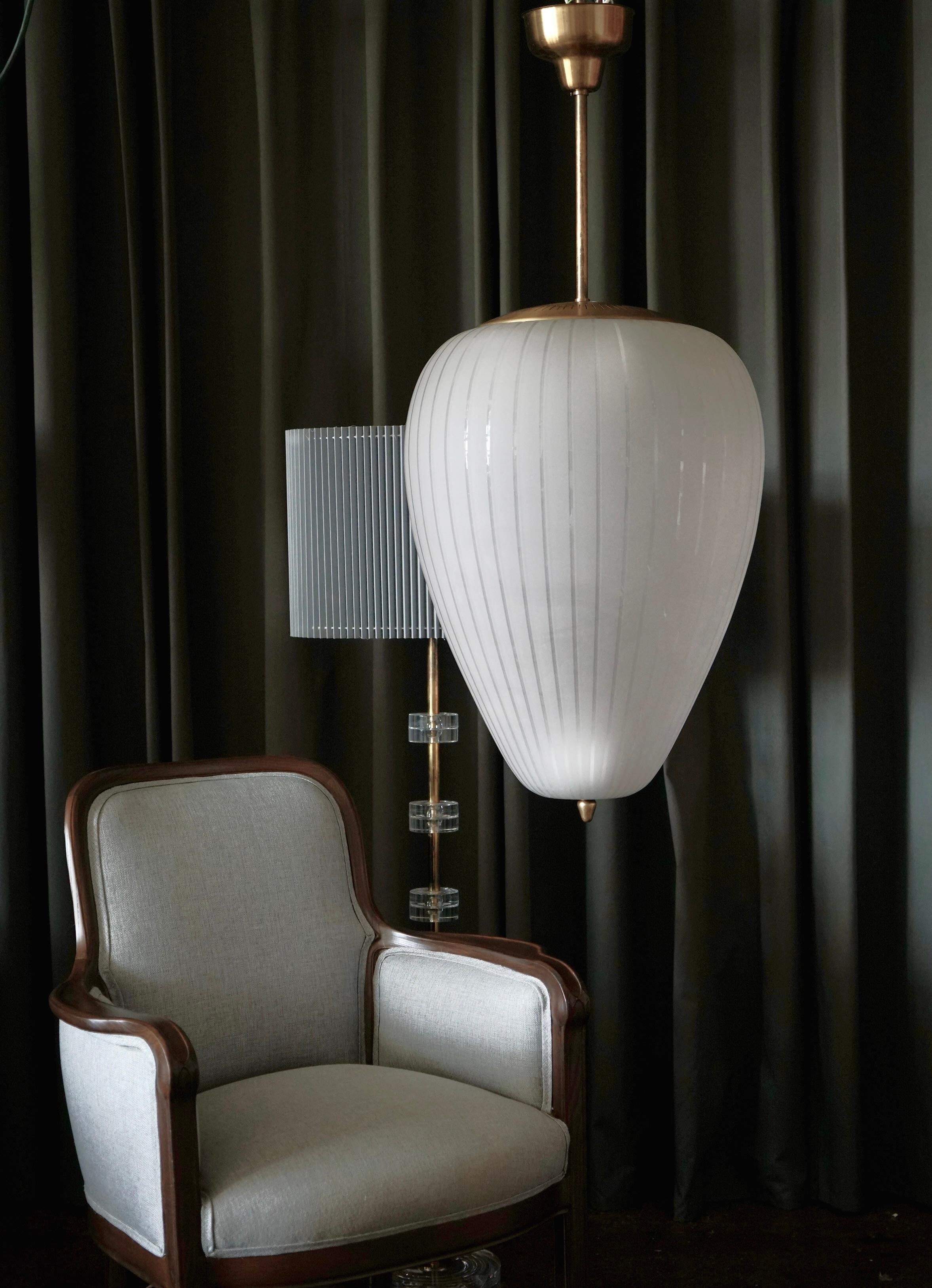 A pair of oversized lighting pendants produced by Asea, Sweden, Circa 1940th. Sandblasted handblown glass shade on brass hardware with 8 Edison type sockets. Dimensions : Glass H 26