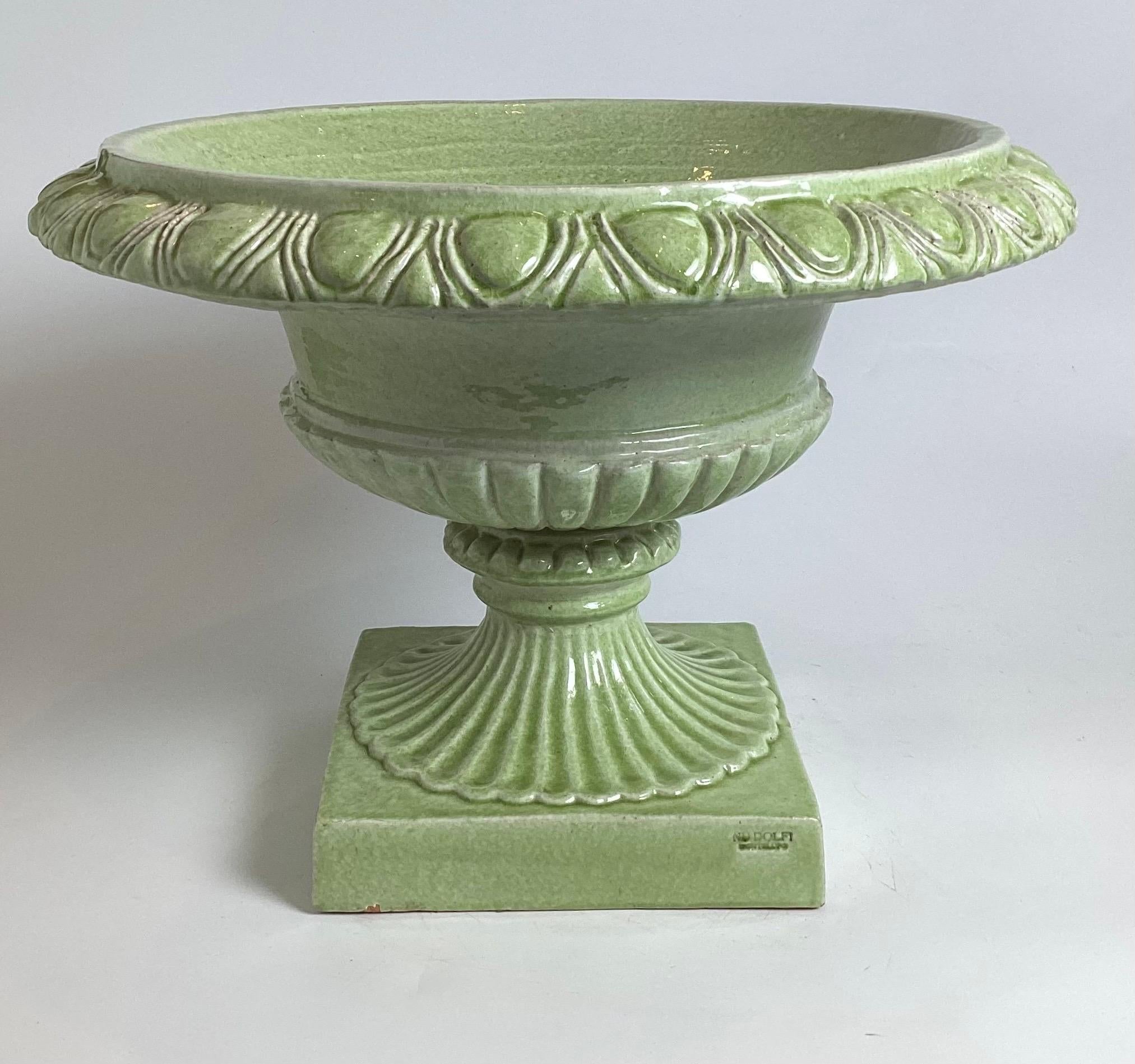 A handsome pair of green tin glazed Faience earthenware low urns. The classic form made in Italy for the wold famous new york city retailer, Bergdorf Goodman