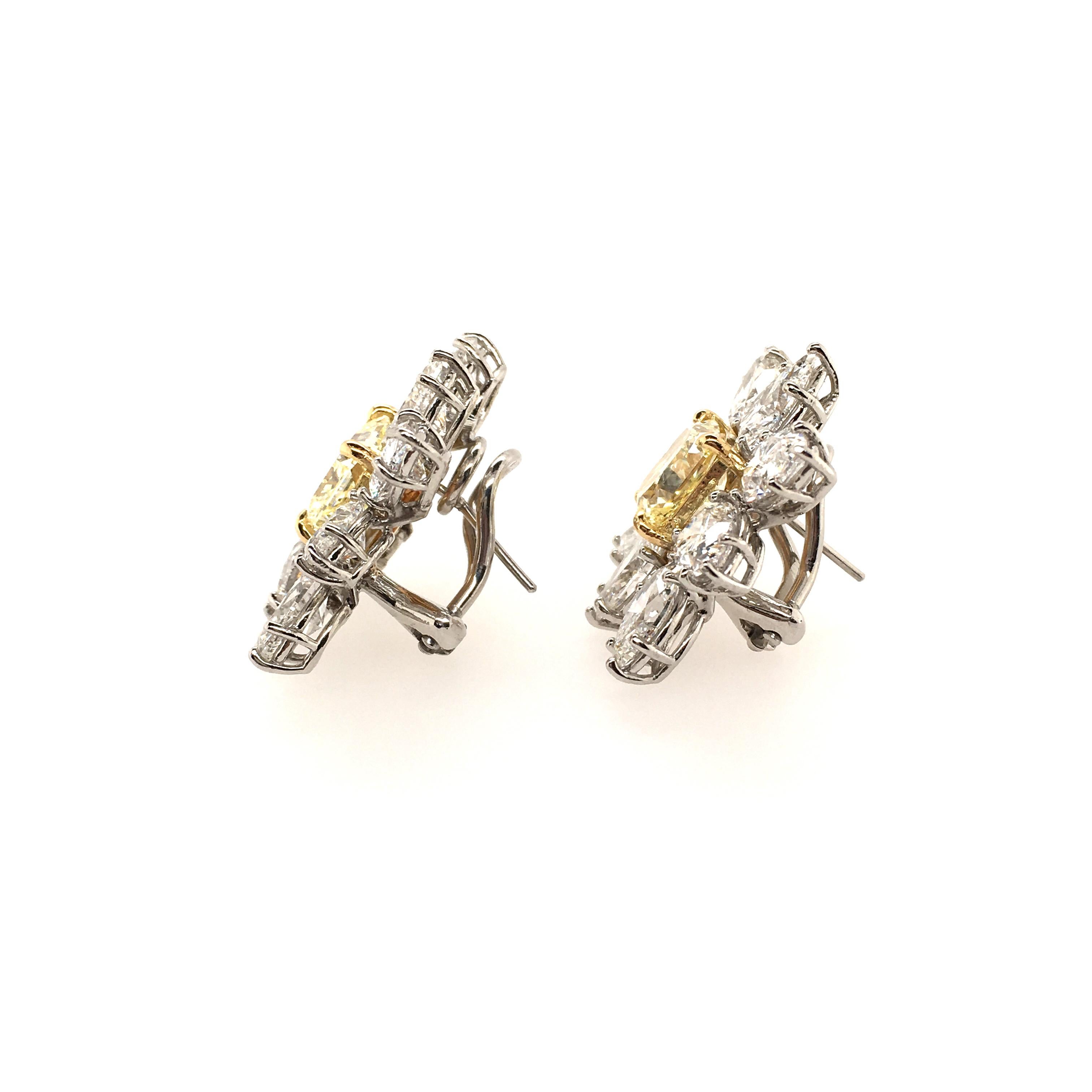 A pair of platinum, 18 karat yellow gold, fancy yellow diamond and diamond earrings. Each set with a fancy yellow cut cornered square modified brilliant, within a pear and marquise cut diamond surround. Fancy yellow diamonds weigh 2.38 and 2.49