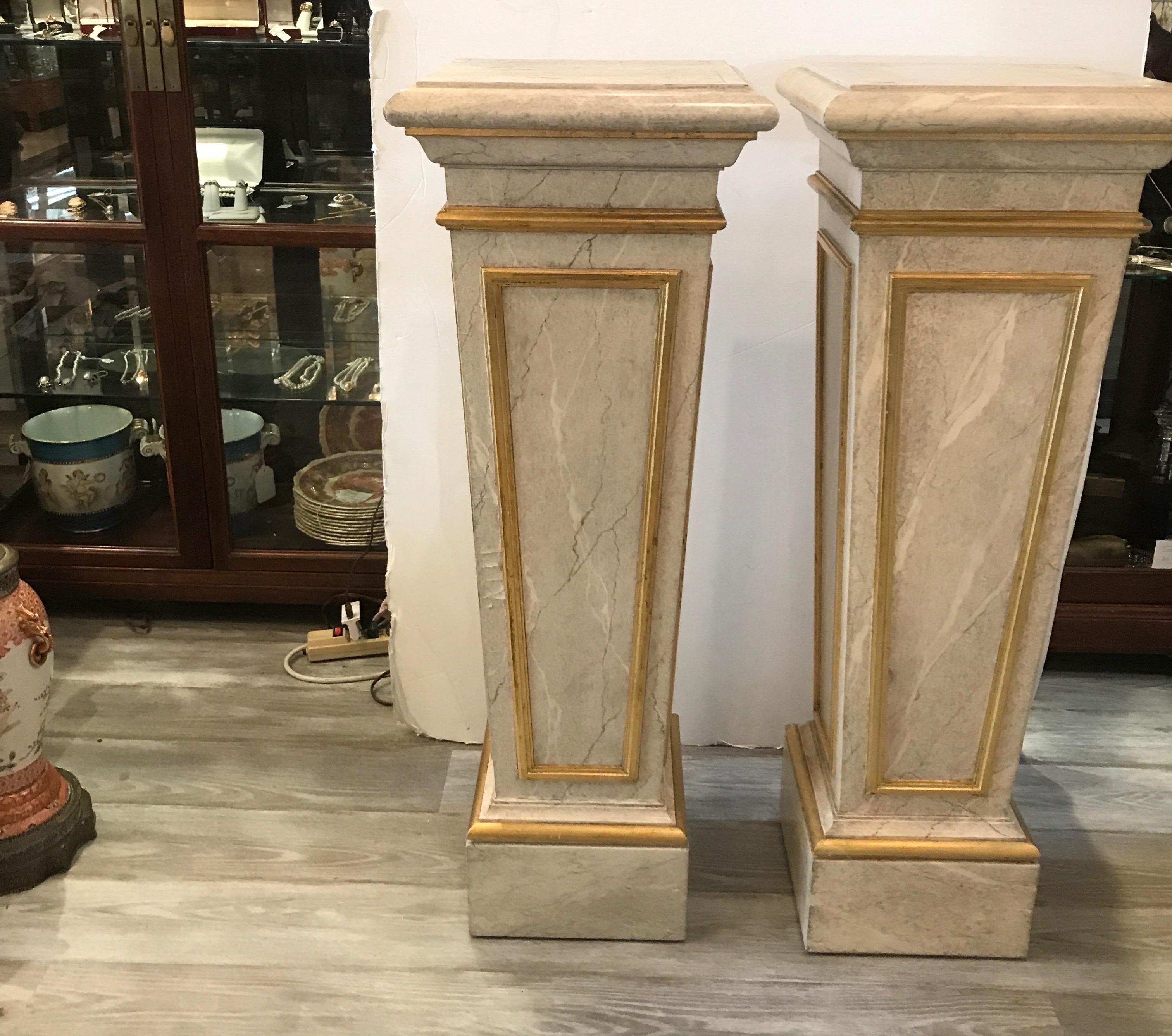 A handsome pair of faux painted marble and gilt pedestals. The hardwood is painted in a light marble with veining with gilt accents.