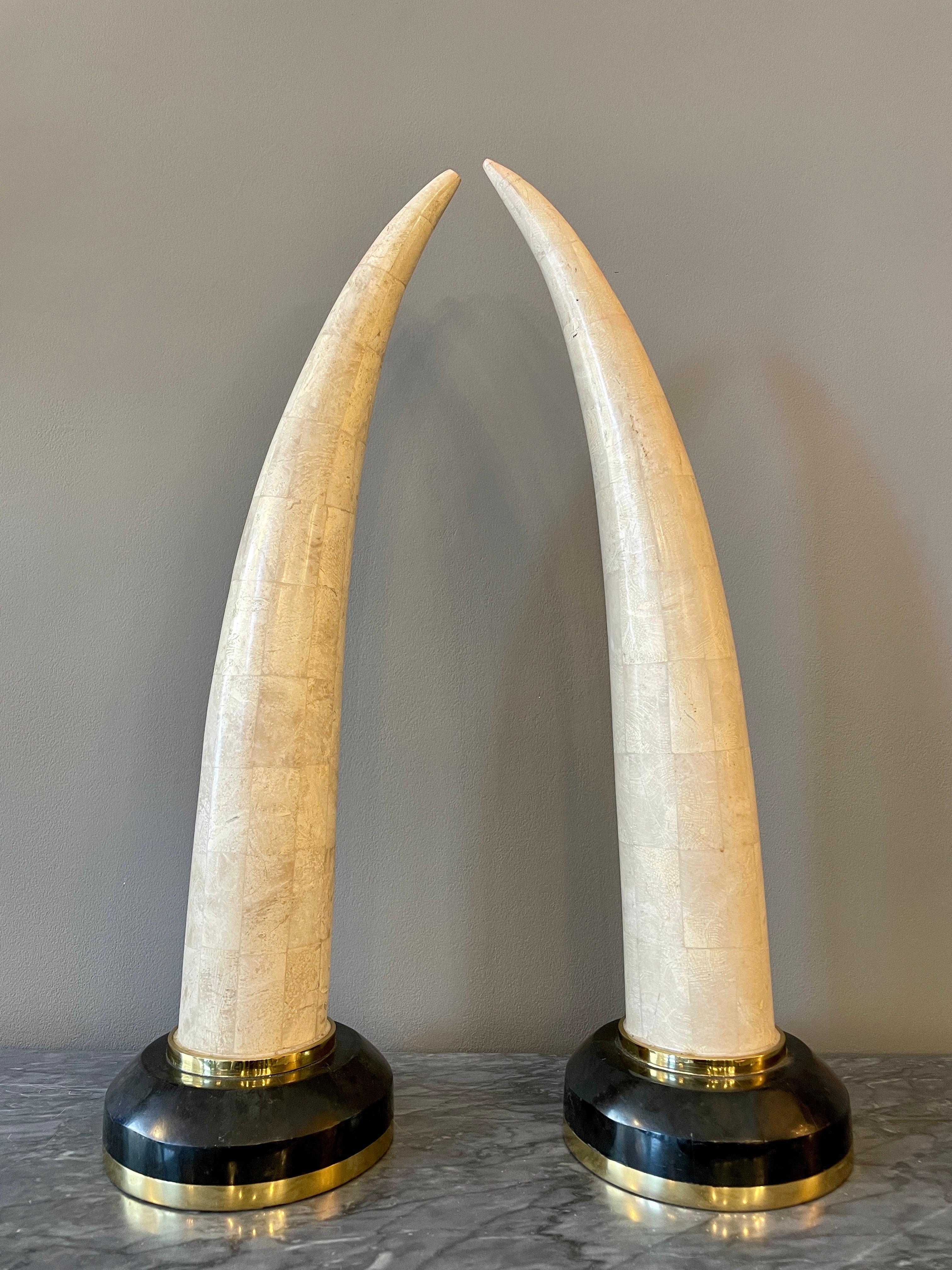 A pair of tall faux tusks in tessellated marble mounted on dark marble plinths with brass accents.

A tessellation or tiling is the covering of a surface, often a plane, using one or more geometric shapes, called tiles, with no overlaps and no