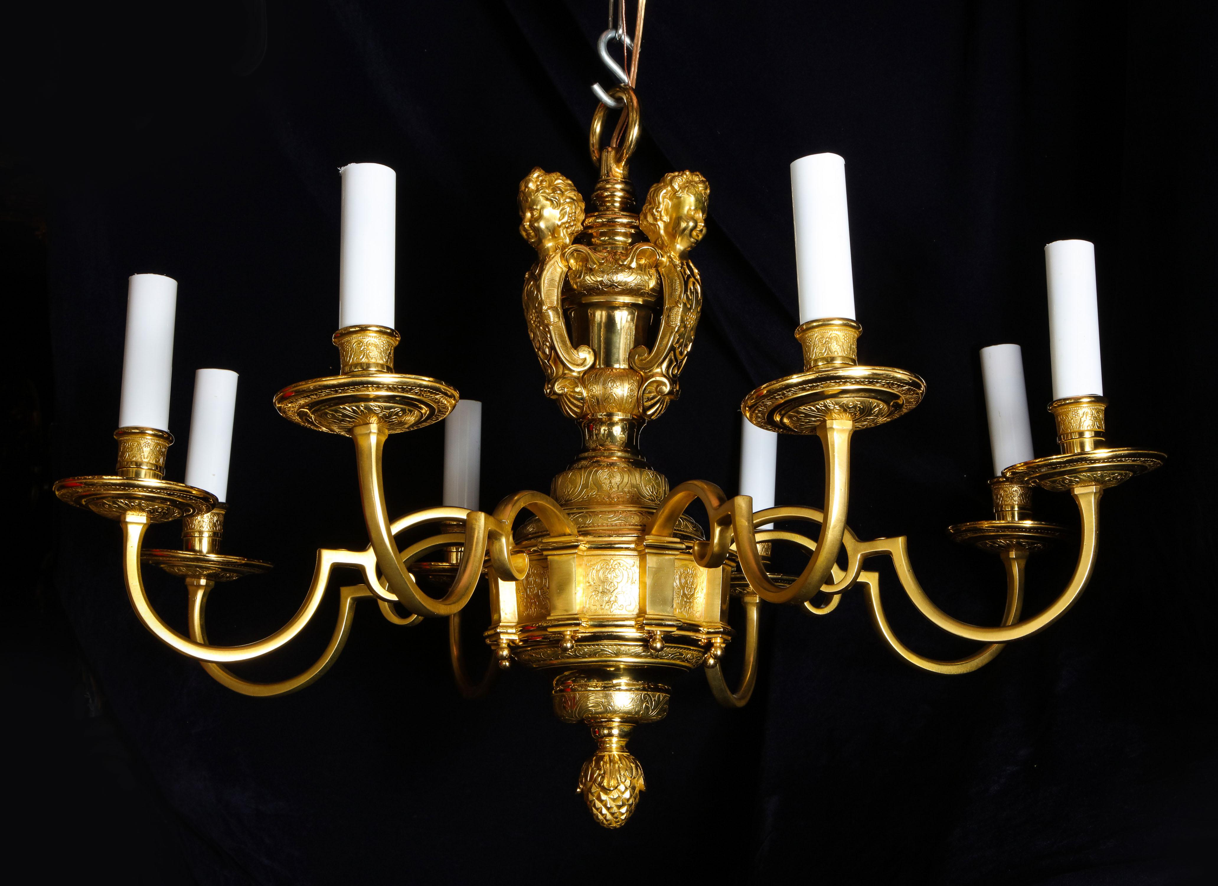 A pair of fine antique French Louis XVI style gilt bronze eight-arm chandeliers of superb workmanship embellished neoclassical hand chased motifs and further adorned with figural masks of cupids.