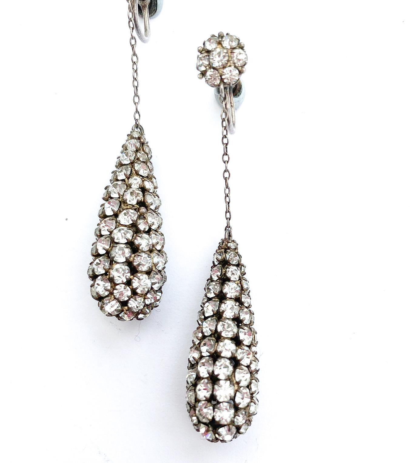 Simple classic and very elegant clear paste drop earrings, totally capturing original 1920s style. Constructed with a metal drop with settings,upon which sit the clear pastes, secured with individual claws on each stone. With their original screw
