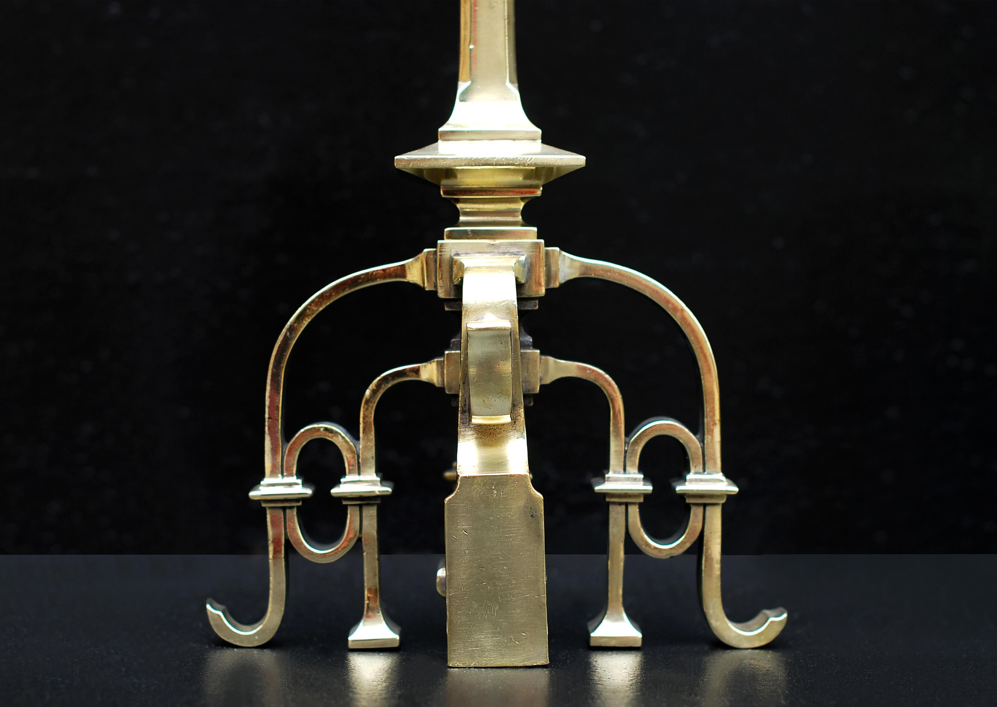 Una coppia di chenet in ottone in stile gotico francese con forma a volute e piccoli fiori al centro sormontati da piani tondi. Metà del XIX secolo.

Altezza:	550 mm      	21 ⅝