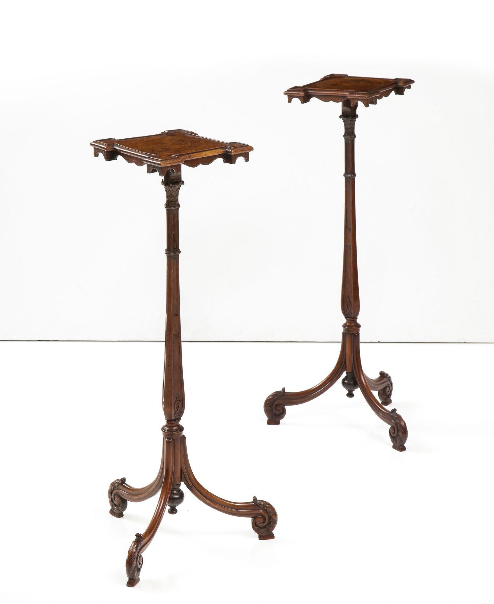 A pair of finely carved 18th century Georgian mahogany stands with quatrefoil tops and fret drops on tall, slender ringed baluster turned shafts with fiddlehead fern carved tripod bases. England, circa 1760.