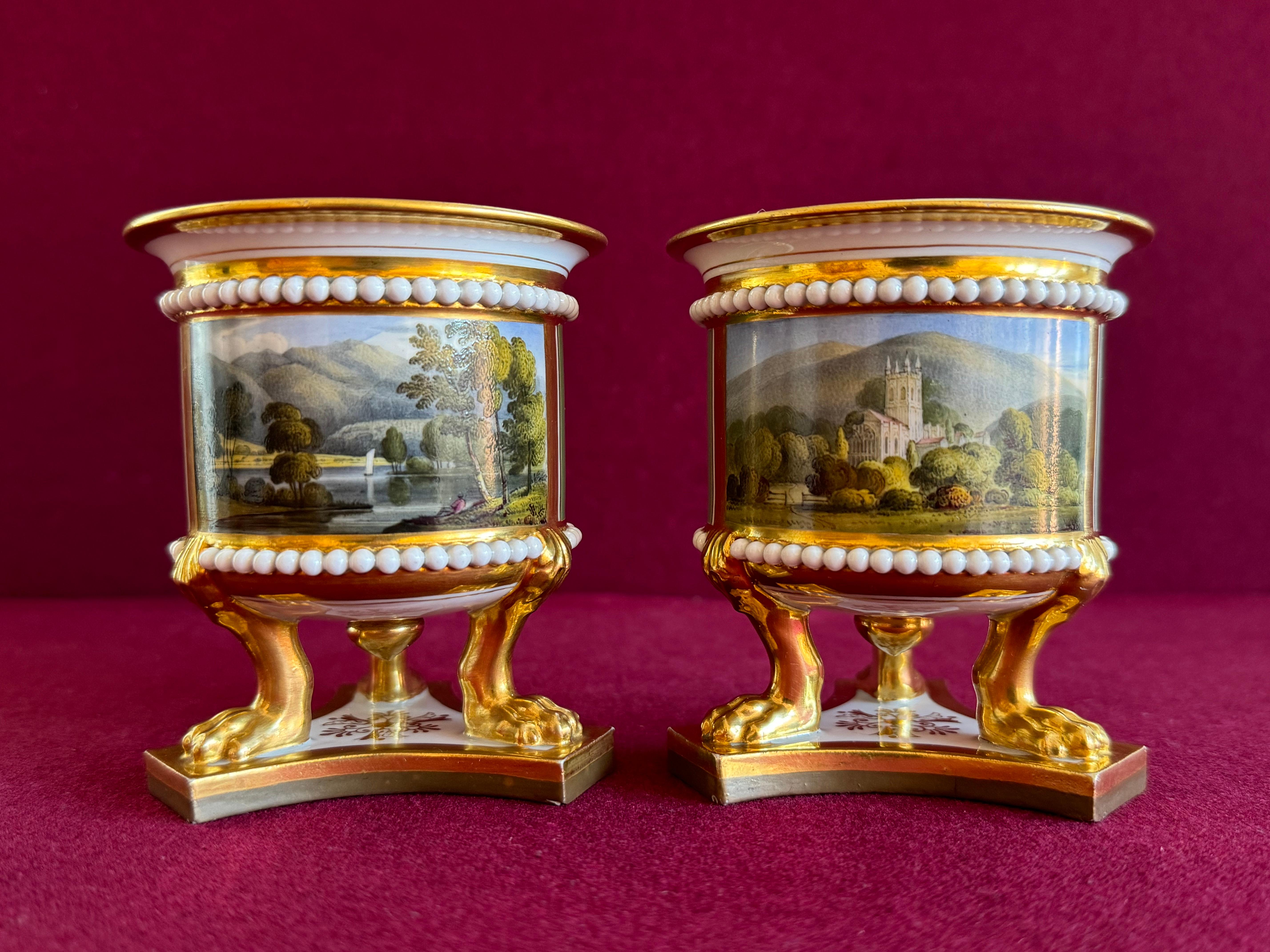 A fine pair of Flight, Barr and Barr Worcester Porcelain Vases c.1820. Of superb quality, each with bands of applied white ‘pearls’ and with a panel painted with views of 'Malvern Church Worcester' and 'Keswick Lake' reserved on a green ground, and