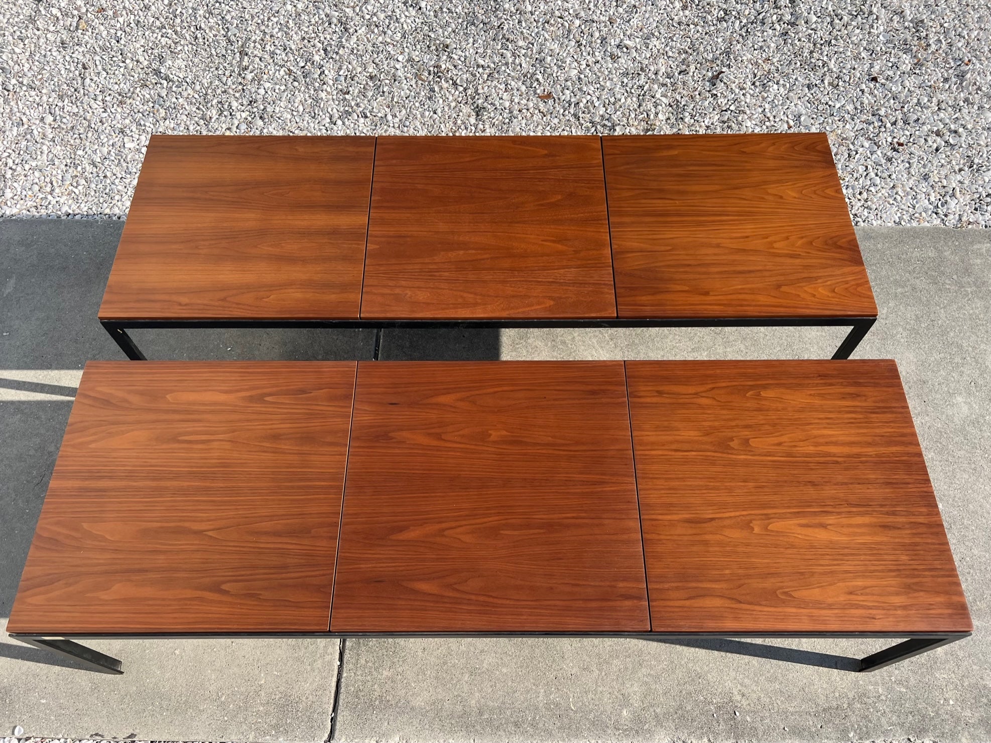 A pair of classic Florence Knoll for Knoll angle iron coffee tables or benches with bookmatched walnut tops.  Beautiful veneer, quality early Knoll production. Very practical and timeless, minimalist design. Heavy angled T iron frames-each one