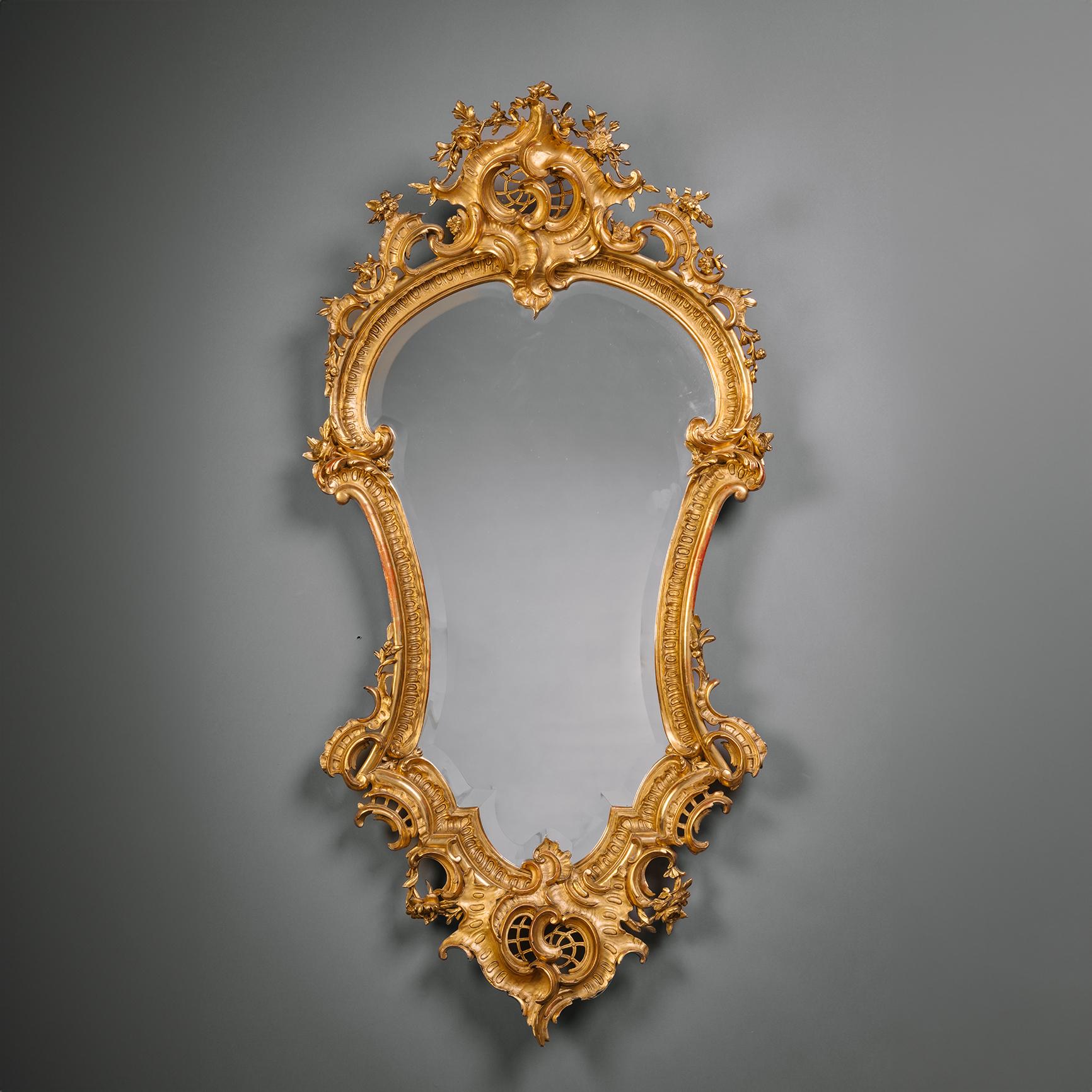 Ein seltenes und großes Paar von Florentine Cartouche-förmigen Giltwood Wandspiegeln.

Jede von ihnen wird von einer kunstvoll durchbrochenen Rocaille mit Muscheln und Schleifenblumen gekrönt. Die  Rahmen um die kartuschenförmige Platte mit