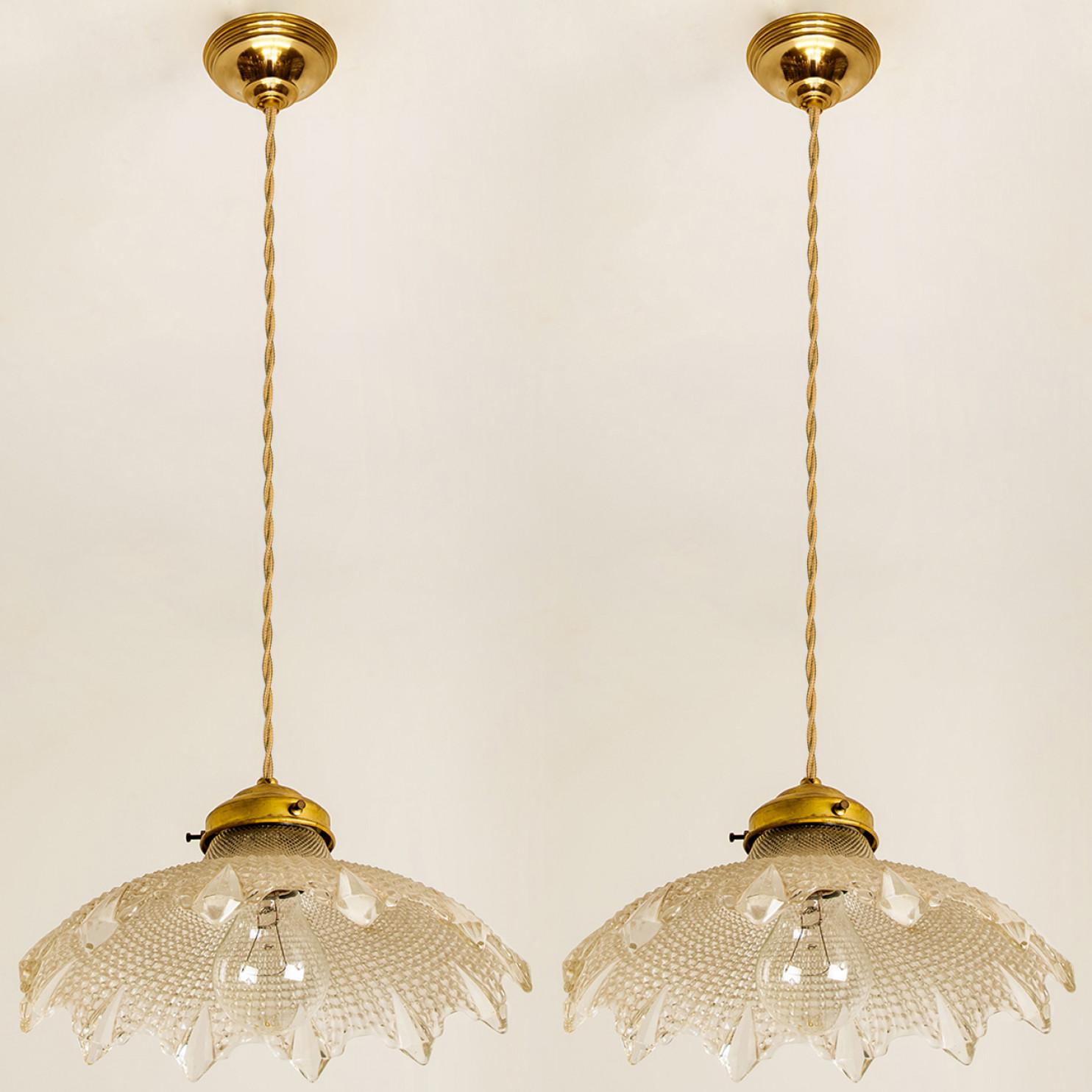 A pair of gorgeous hanging light fixture, in Art Deco style made in Europe, France. A flower-like shape with diamond glass details and a brass fixture.

A very elegant piece which is highly suited for just about any room. We can deliver different