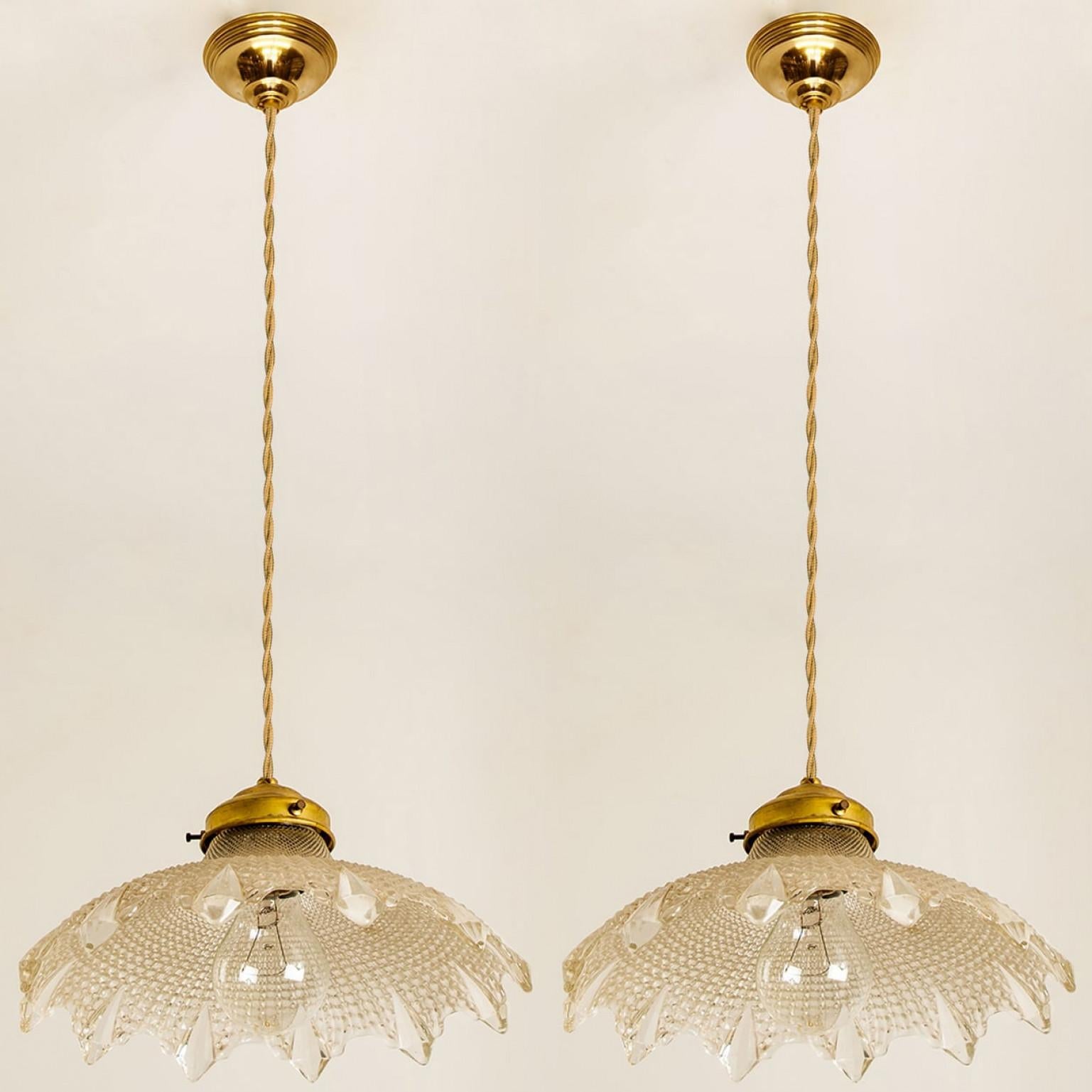 A pair of gorgeous hanging light fixture, in Art Deco style made in Europe, France. A flower-like shape with diamond glass details and a brass fixture.

A very elegant piece which is highly suited for just about any room. We can deliver different