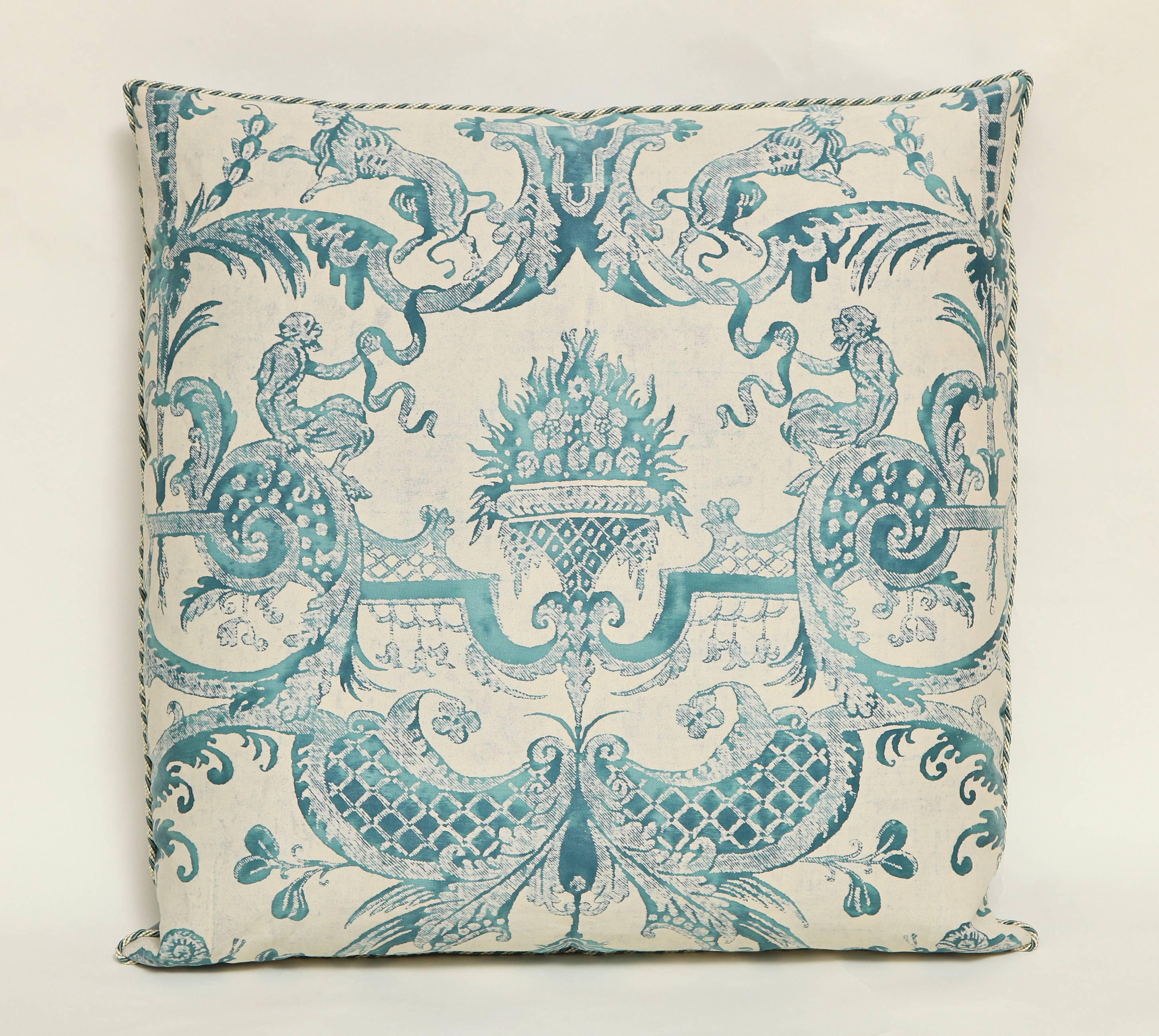 A pair of Fortuny fabric cushions in the Mazzarino print, peacock blue and ivory colorway with white and blue braided edging and grey or silver silk taffeta backing, the pattern, a 17th century French design named after Cardinal Mazarin at the Court