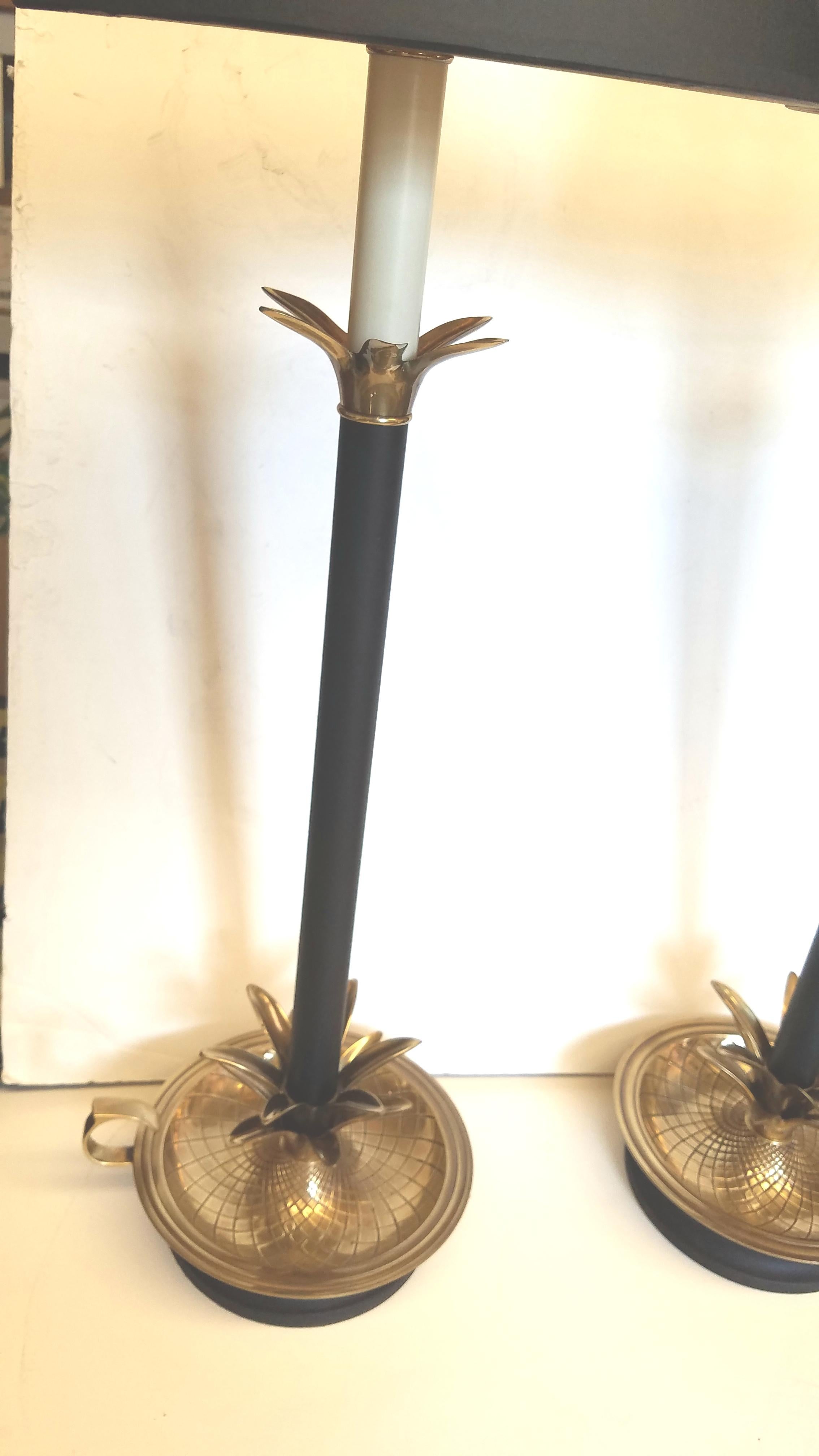 A wonderful pair of tall Frederic Cooper candlestick lamps with black parchment shades with gold foil liners.