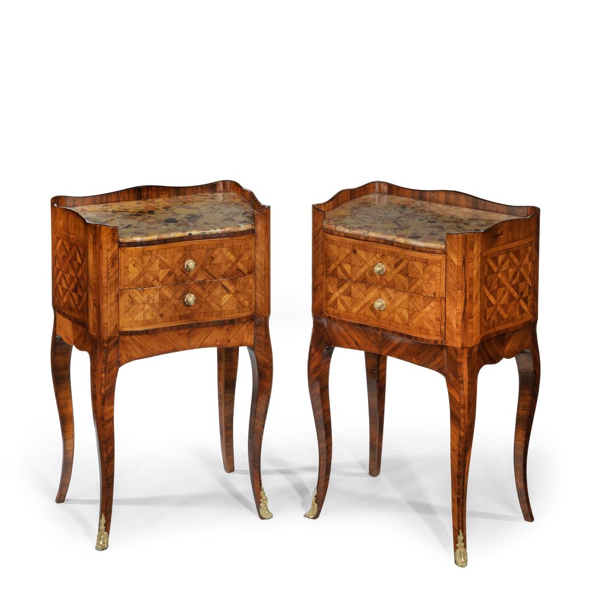 A pair of freestanding French kingwood bedside cabinets, each of bombe, serpentine form with a marble top above two small drawers, with flowerhead handles, decorated throughout with cube trellis and cross banding. French, circa 1900.