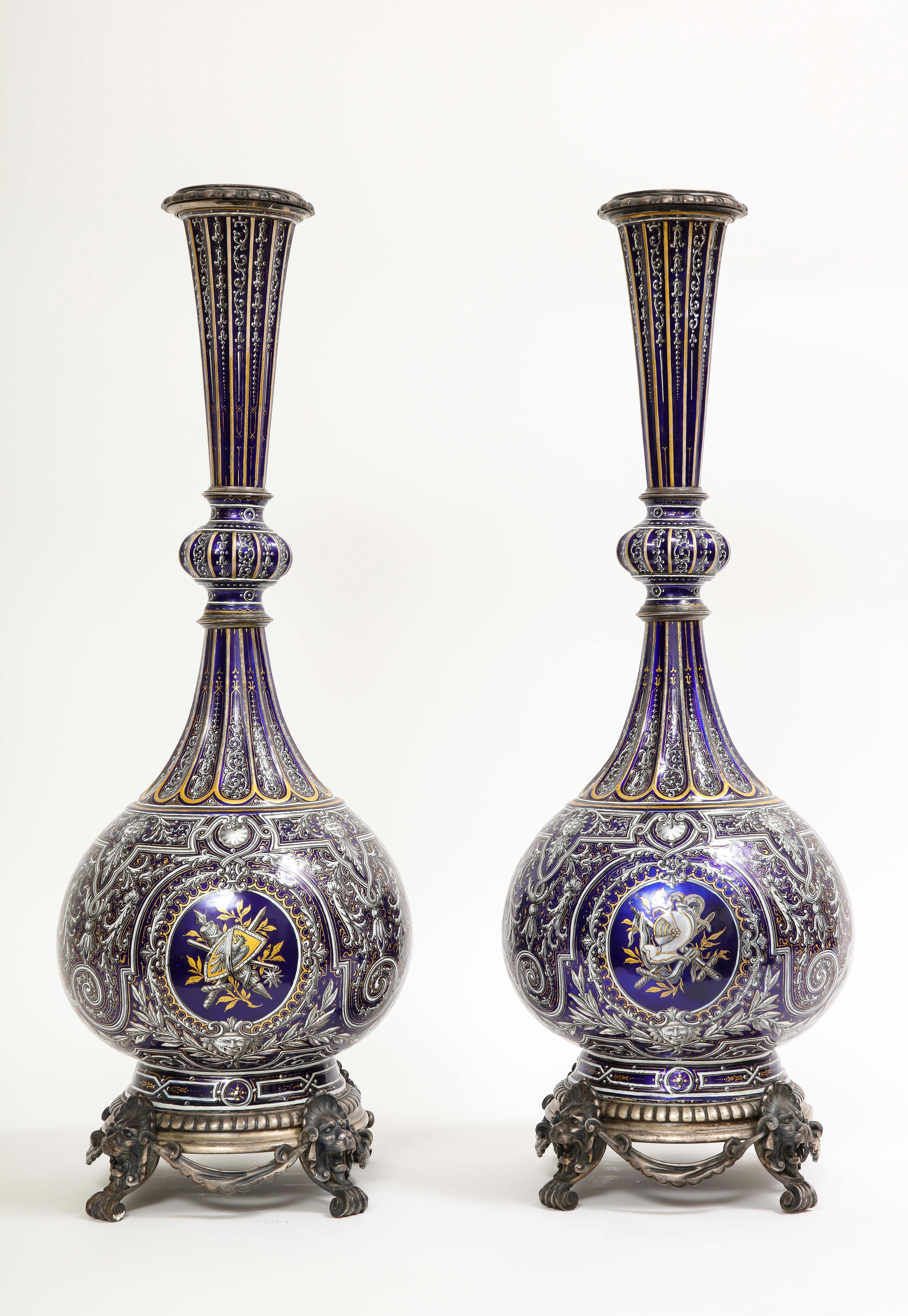 A fantastic and large pair of French 19th century silvered bronze mounted limoges enameled copper armorial vases. Each vase has a bulbous body with a wasting neck. The tops and bases of the vases are mounted on silvered bronze mounts, each with