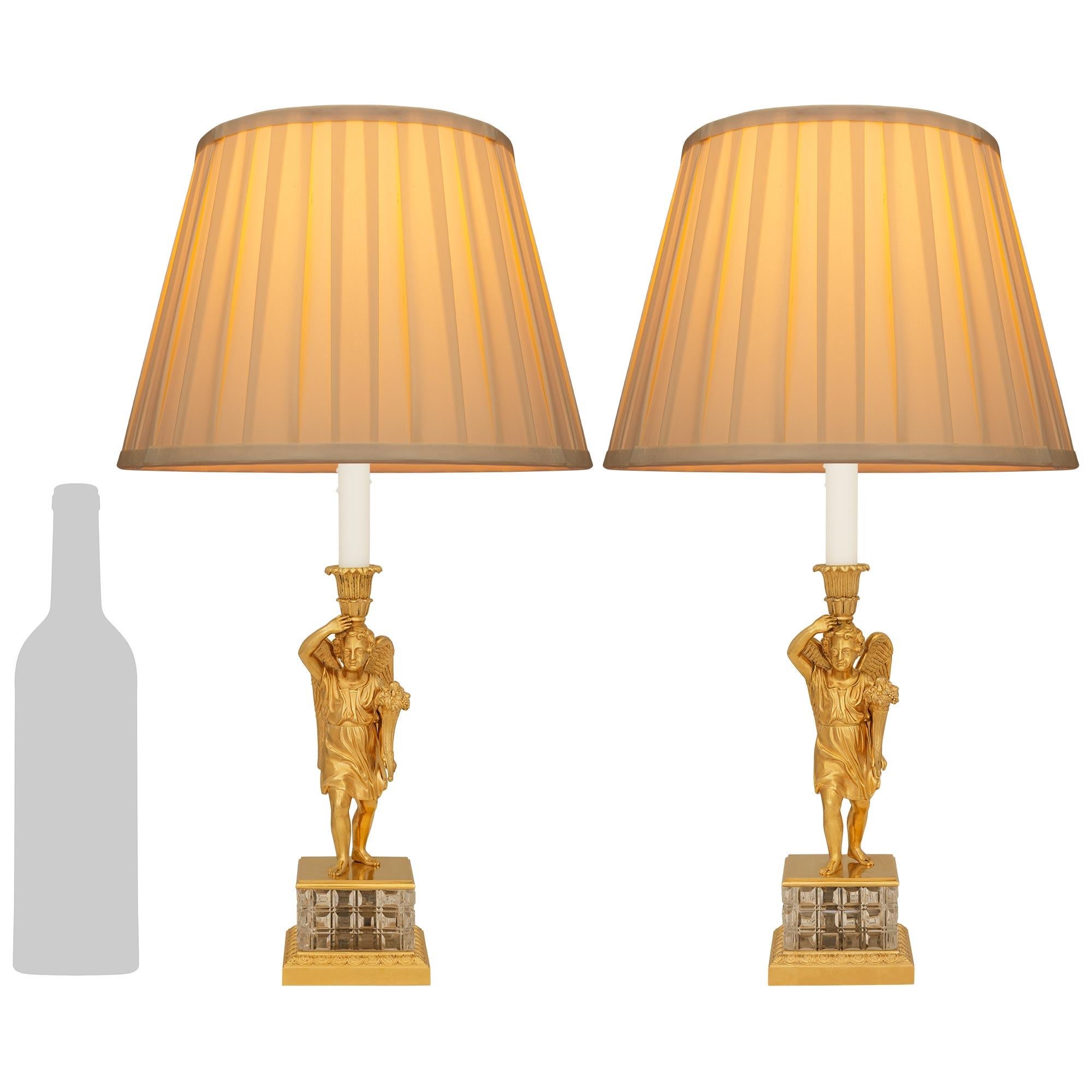 A sensational pair of French 19th century Charles X Period Ormolu and Crystal lamps. Each stunning candlestick mounted into a lamp is raised by a square Ormolu base with a cut angled and Rais de Coeur trim. Above is the square Crystal pedestal with