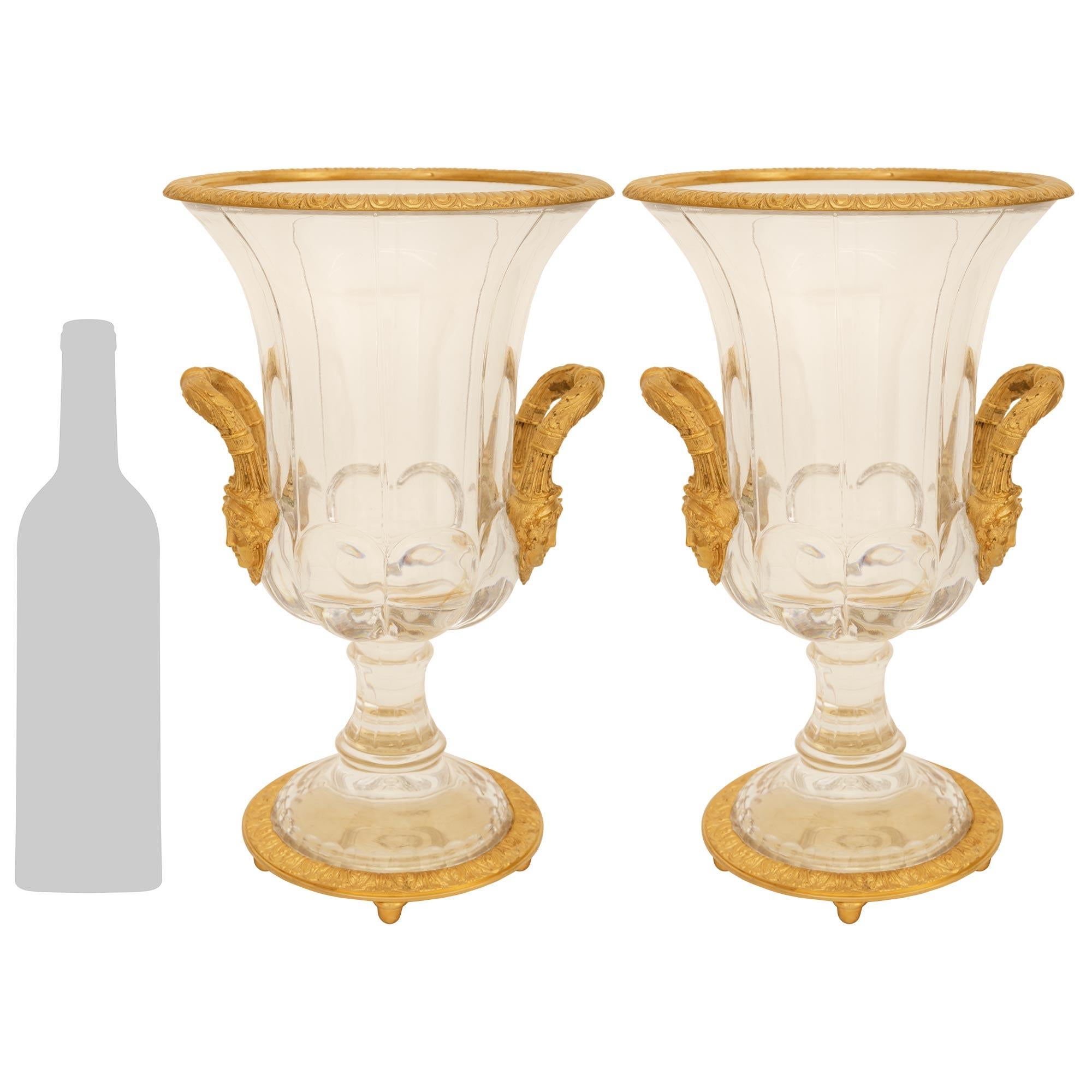 Una coppia impressionante e di alta qualità di urne in cristallo Baccarat e ormolu del XIX secolo di St. Charles X. Ogni elegantissima urna a forma di campana è sollevata su una base circolare in Ormolu decorata con una fascia Rais de Coeur, che
