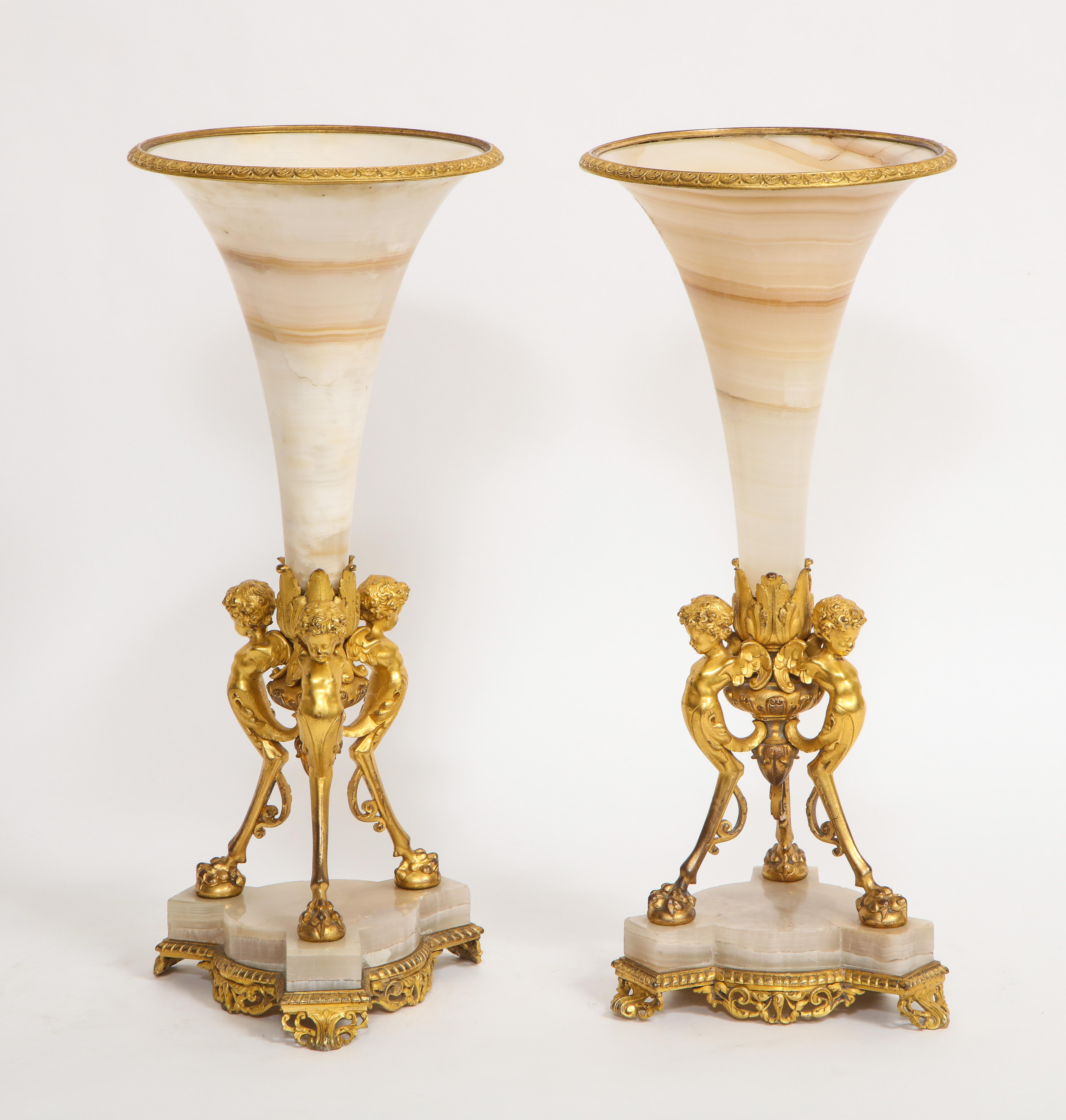 A Fabulous Pair of French 19th Century Figural Dore Bronze Mounted Alabaster Trumpet Vases. Each Egyptian alabaster vase is beautifully hand-carved and hand-polished with the finest stone workmanship. The vases are mounted on incredible quality dore