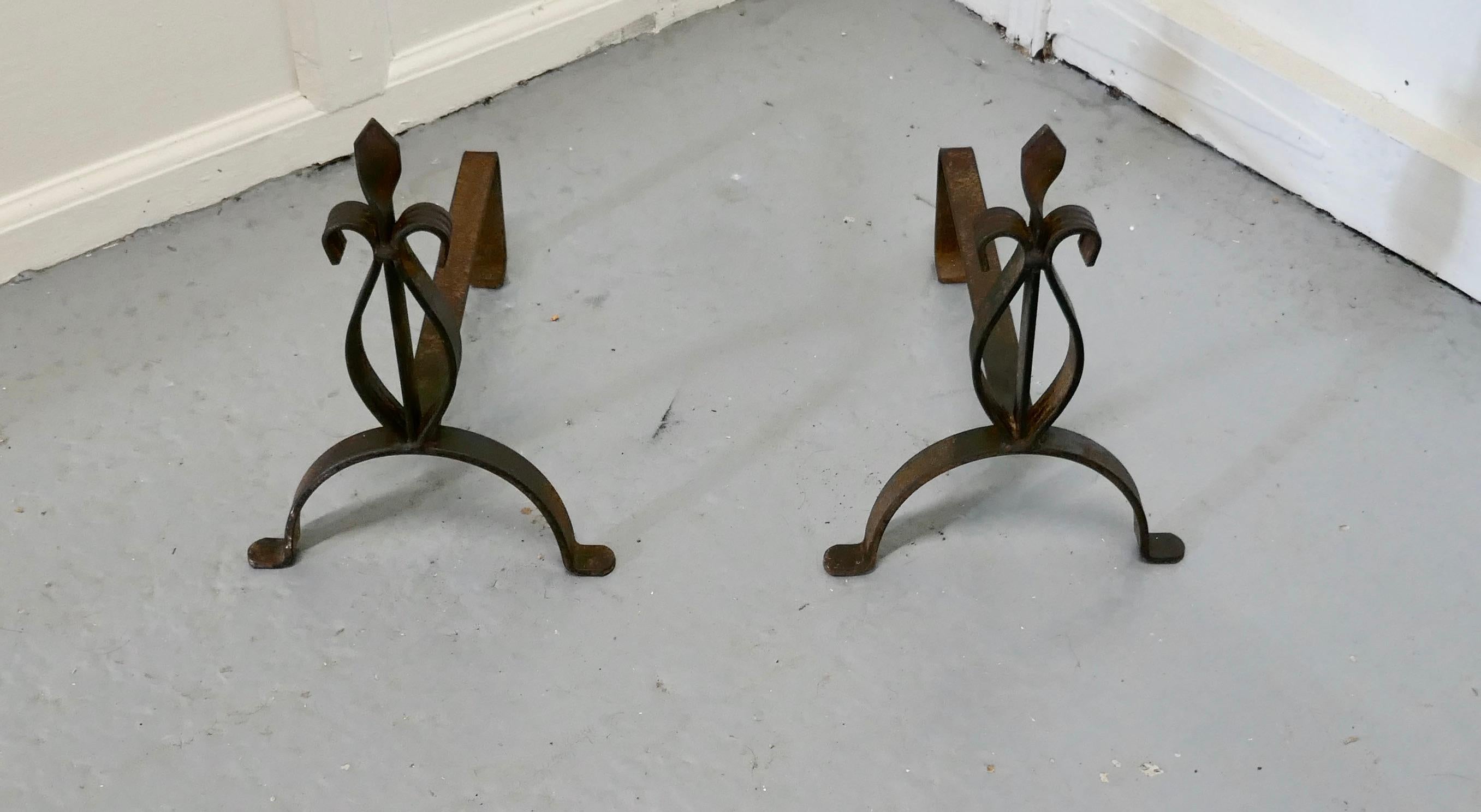 A pair of French 19th century iron andirons or fire dogs

This is a heavy pair of antique andirons, they are made in iron, and stand on wide front foot with a decorative Fleur de Lys at the top
The andirons are 13” high, 14” long and are 10” wide