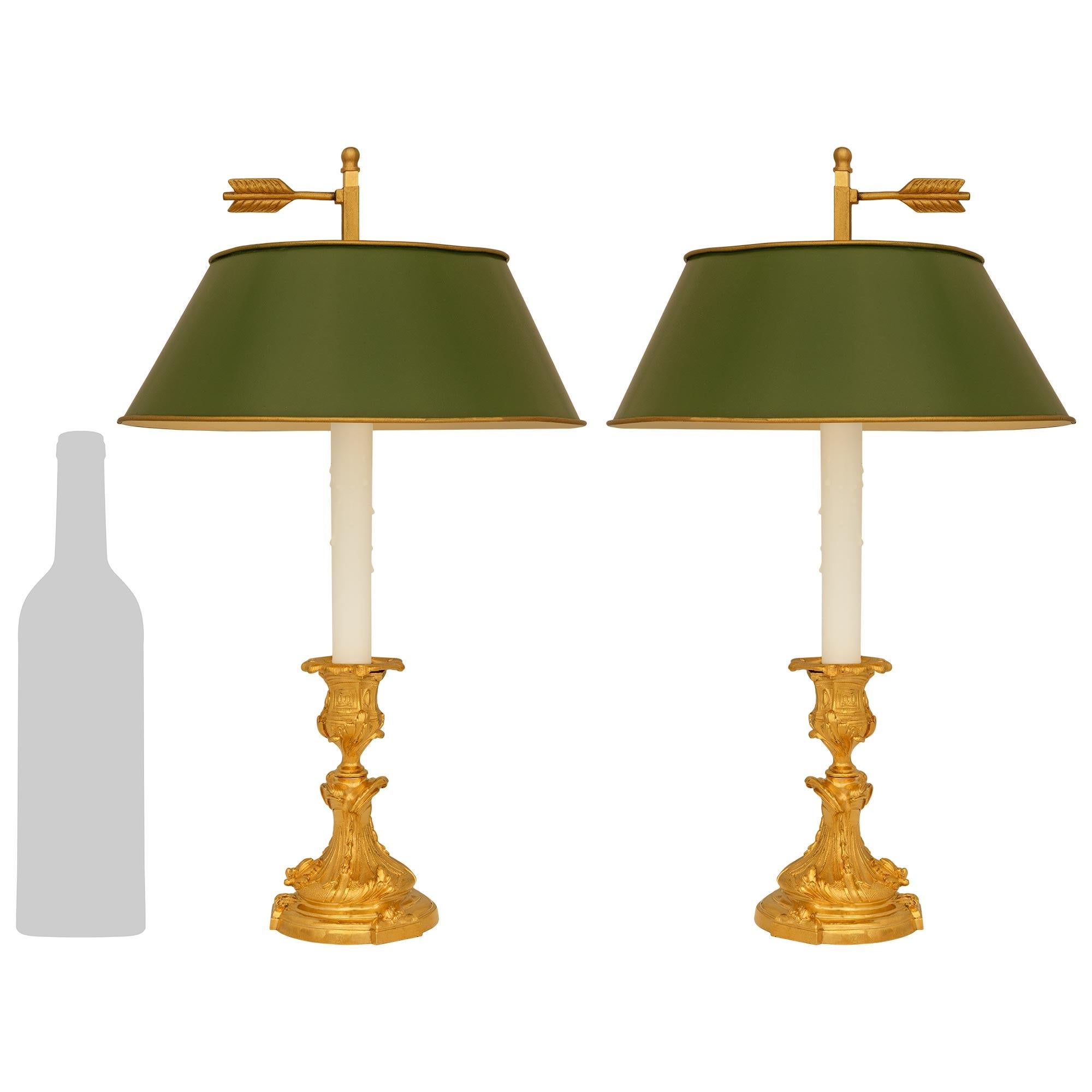 Ein elegantes und äußerst dekoratives Paar französischer Lampen aus dem 19. Jahrhundert aus Ormolu und Tole Bouillotte. Jeder wunderbare, zu einer Lampe montierte Kerzenhalter steht auf einem runden Ormolu-Sockel mit vorspringenden Reserven, die mit