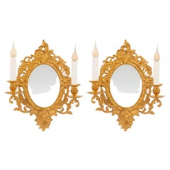 Antique A pair of French 19th century Louis XV st. Ormolu mirrored sconces
