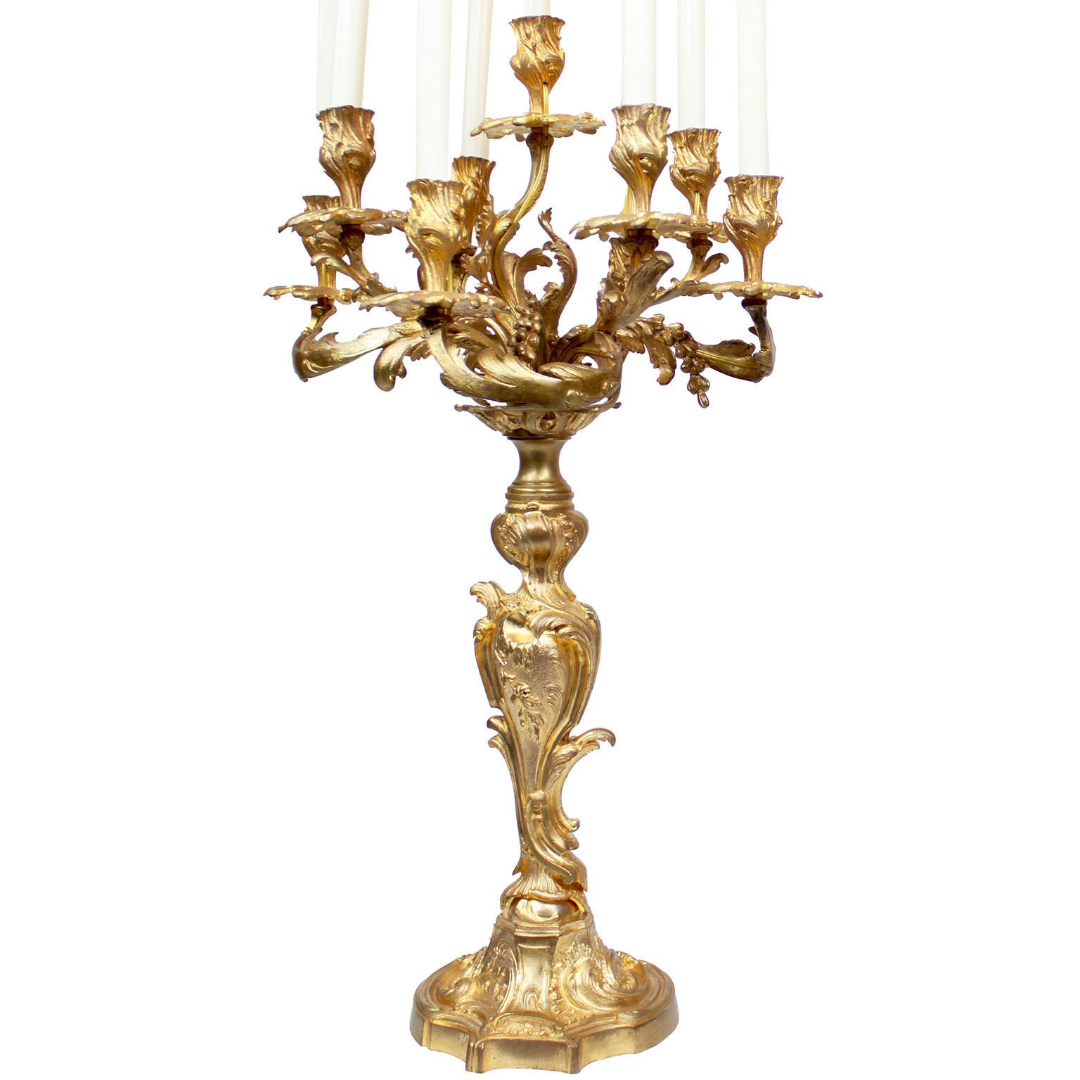 Ein Paar französische Neun-Licht-Kronleuchter aus vergoldeter Bronze im Stil Louis XV des 19. Das beeindruckende Paar Kandelaber steht jeweils auf einem floralen Sockel, der mit neun verschnörkelten Kerzenarmen mit Akanthus-, Blatt- und Fruchtdekor