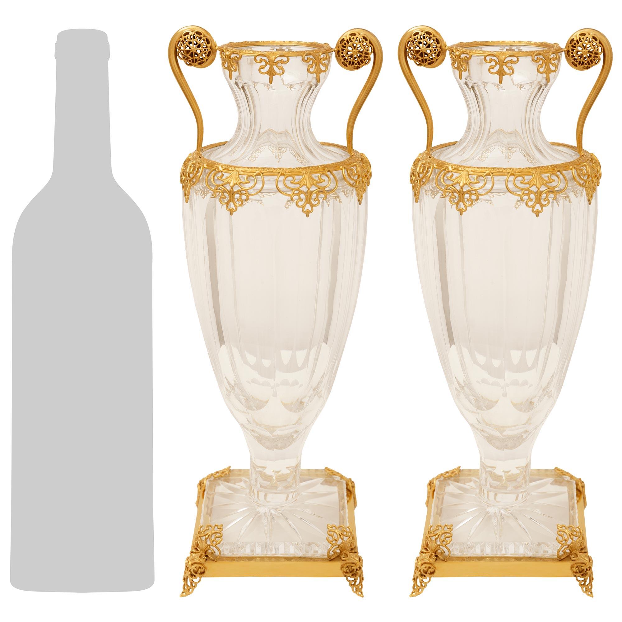 A high quality and most attractive pair of French 19th century Louis XVI st. Baccarat Crystal and Ormolu vases. This stunning pair of vases are raised on square Ormolu bases with scrolled and pierced palmette feet, which securely hold the Baccarat