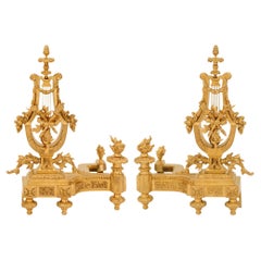 A pair of French 19th century Louis XVI st. Ormolu and Iron andirons